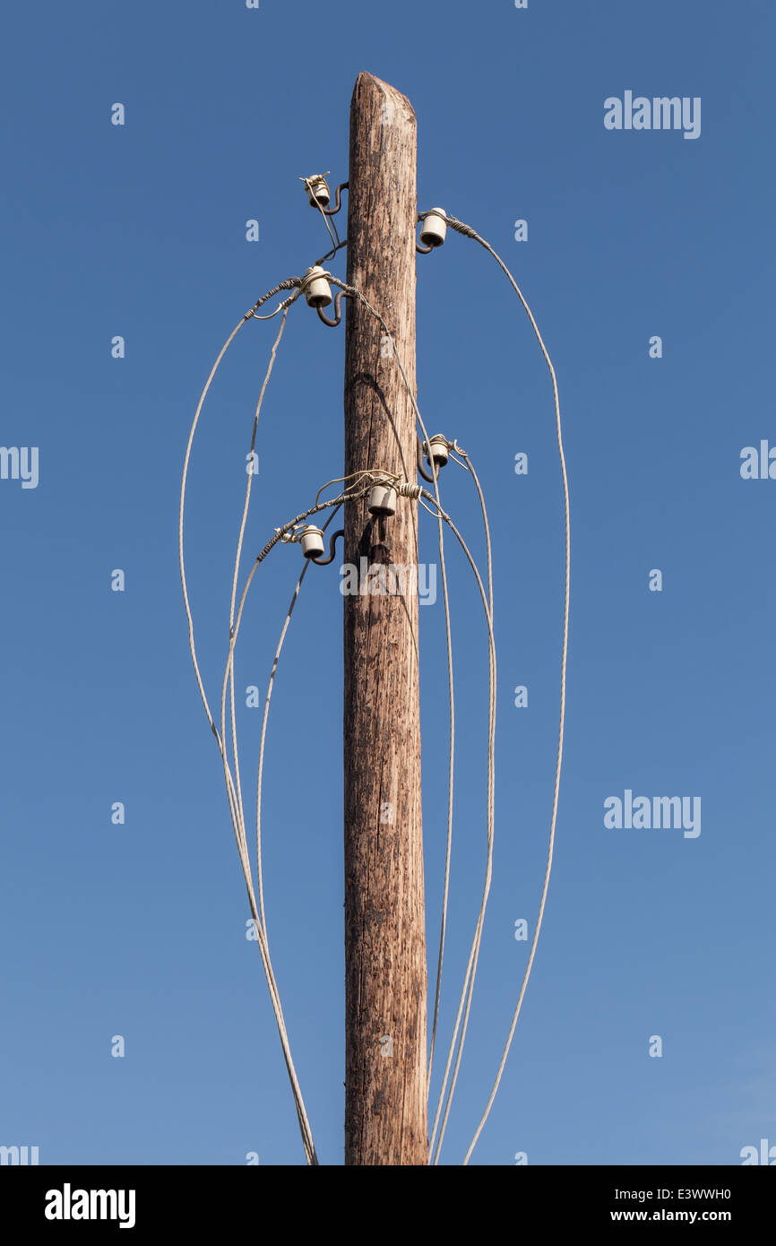 Disconnected electric wires on old wooden pylon Stock Photo