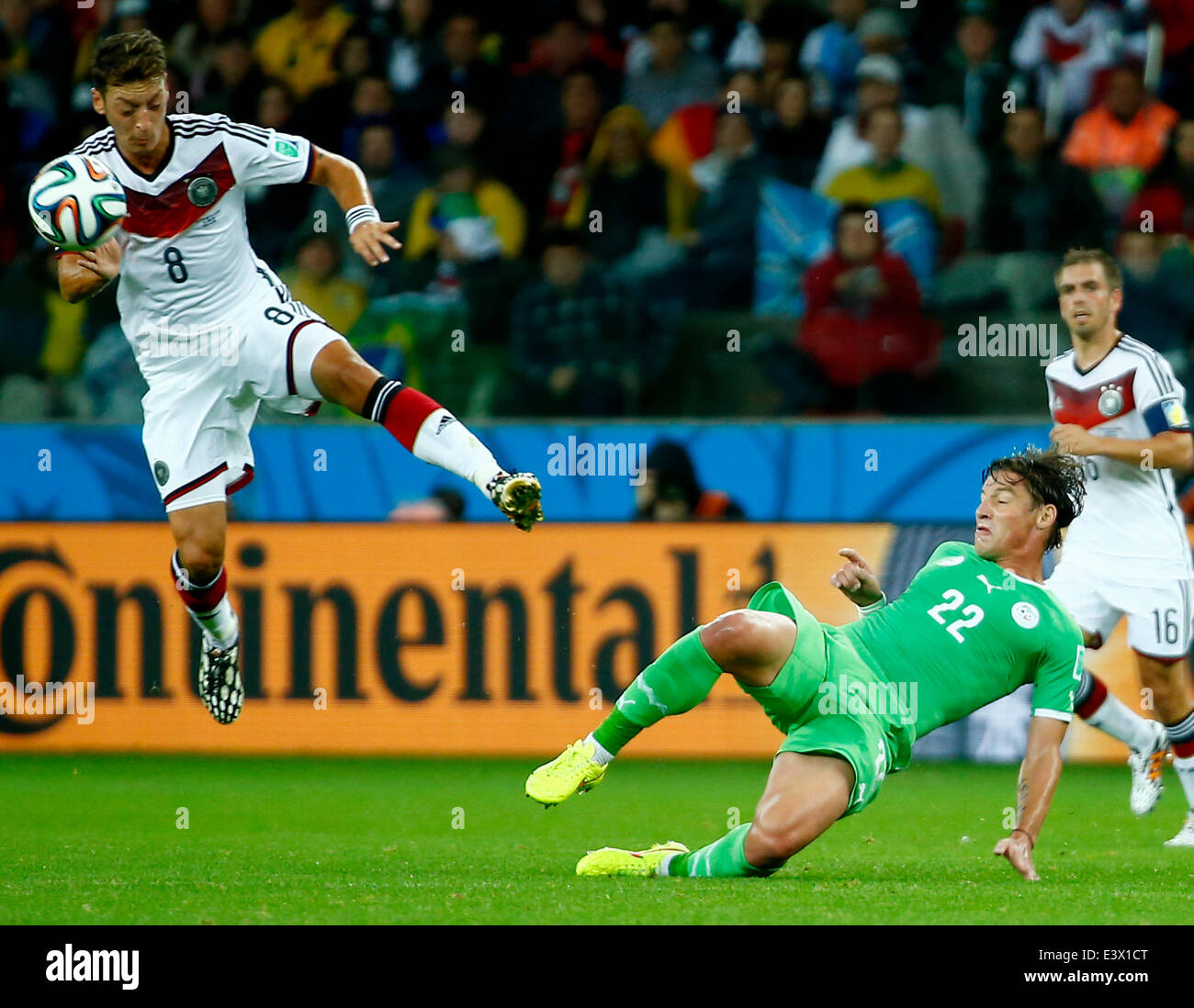 Porto Alegre, Brazil. 30th June, 2014. Germany's Mesut Ozil vies with Algeria's Mehdi Mostefa during a Round of 16 match between Germany and Algeria of 2014 FIFA World Cup at the Estadio Beira-Rio Stadium in Porto Alegre, Brazil, on June 30, 2014. Credit:  Chen Jianli/Xinhua/Alamy Live News Stock Photo