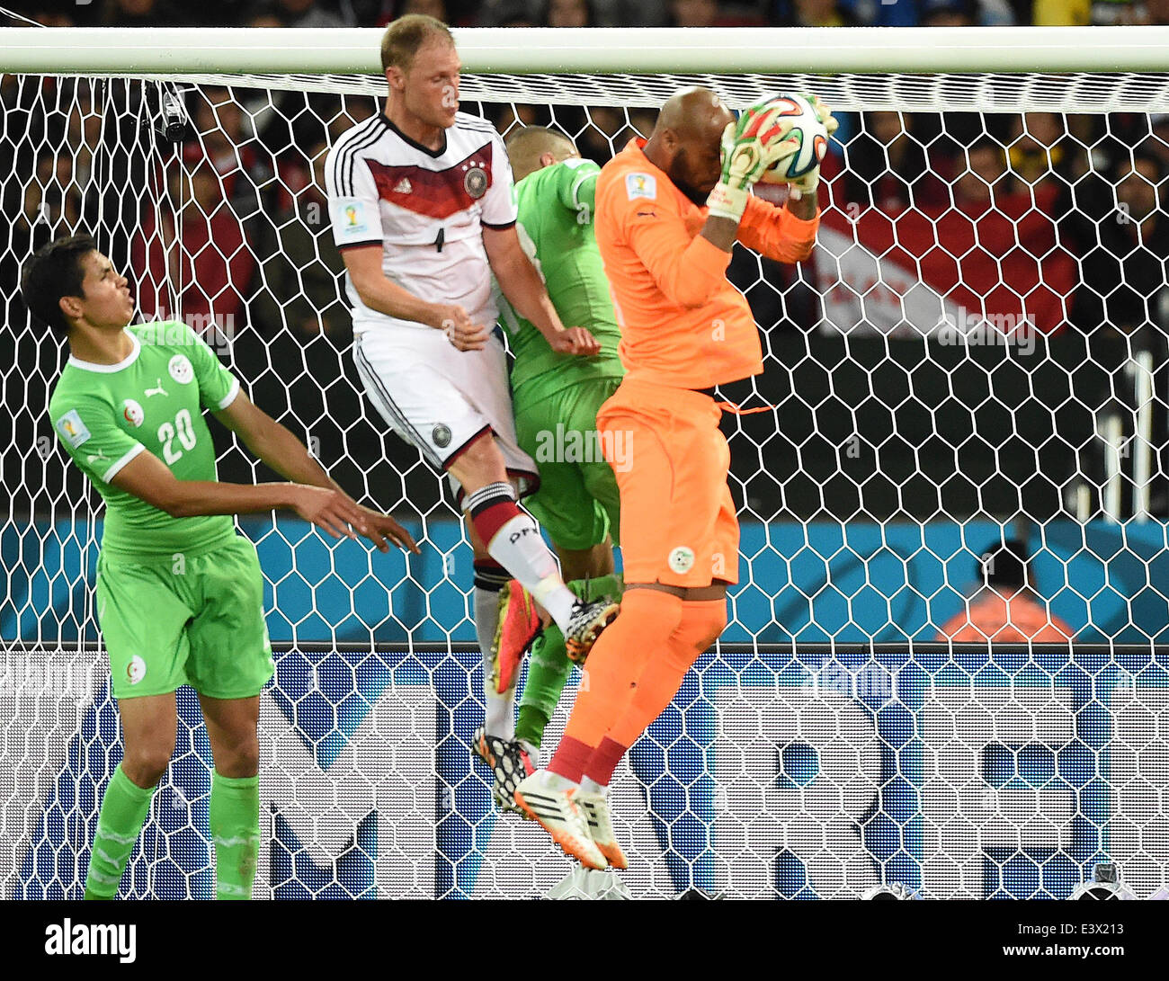 Porto Alegre, Brazil. 30th June, 2014. Goalkeeper Rais Mbolhi (R) of Algeria catches a ball next to Germany's Andre Schuerrle (2-L) during the FIFA World Cup 2014 round of 16 soccer match between Germany and Algeria at the Estadio Beira-Rio in Porto Alegre, Brazil, 30 June 2014. Photo: Marcus Brandt/dpa/Alamy Live News Stock Photo