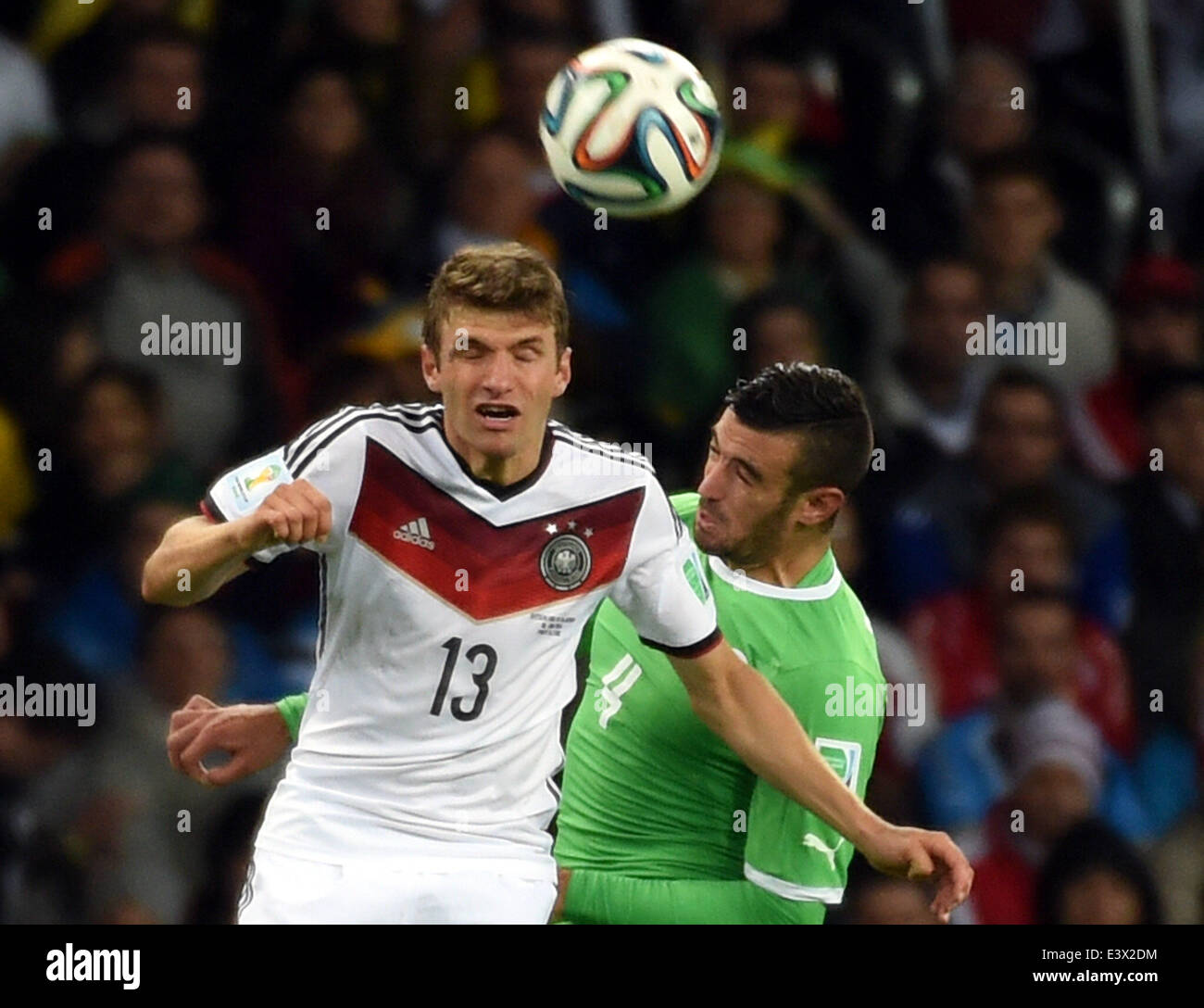 Porto Alegre, Brazil. 30th June, 2014. Germany's Thomas Muller (L) vies with Algeria's Essaid Belkalem during a Round of 16 match between Germany and Algeria of 2014 FIFA World Cup at the Estadio Beira-Rio Stadium in Porto Alegre, Brazil, on June 30, 2014. Credit:  Li Ga/Xinhua/Alamy Live News Stock Photo