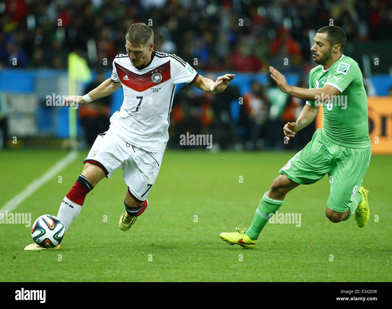 Porto Alegre, Brazil. 30th June, 2014. Germany's Bastian Schweinsteiger vies with Algeria's Medhi Lacen during a Round of 16 match between Germany and Algeria of 2014 FIFA World Cup at the Estadio Beira-Rio Stadium in Porto Alegre, Brazil, on June 30, 2014. Credit:  Chen Jianli/Xinhua/Alamy Live News Stock Photo