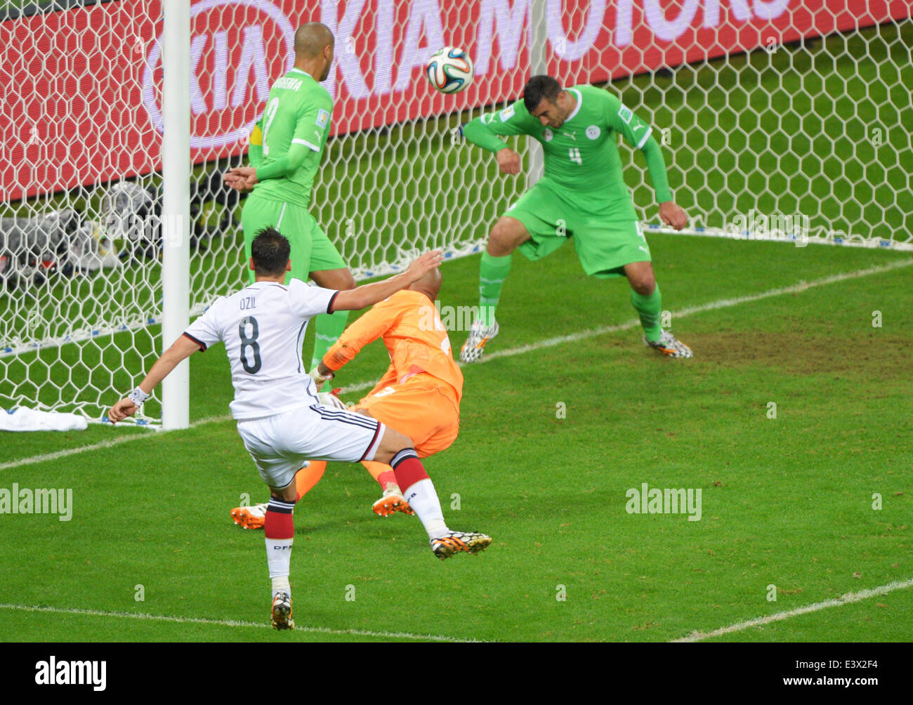 Porto Alegre, Brazil. 30th June, 2014. Germany's Mesut Oezil (L) scores the 2-0 against Algeria's goalkeeper Rais Mbolhi (C) during the FIFA World Cup 2014 round of 16 soccer match between Germany and Algeria at the Estadio Beira-Rio in Porto Alegre, Brazil, 30 June 2014. Photo: Thomas Eisenhuth/dpa/Alamy Live News Stock Photo