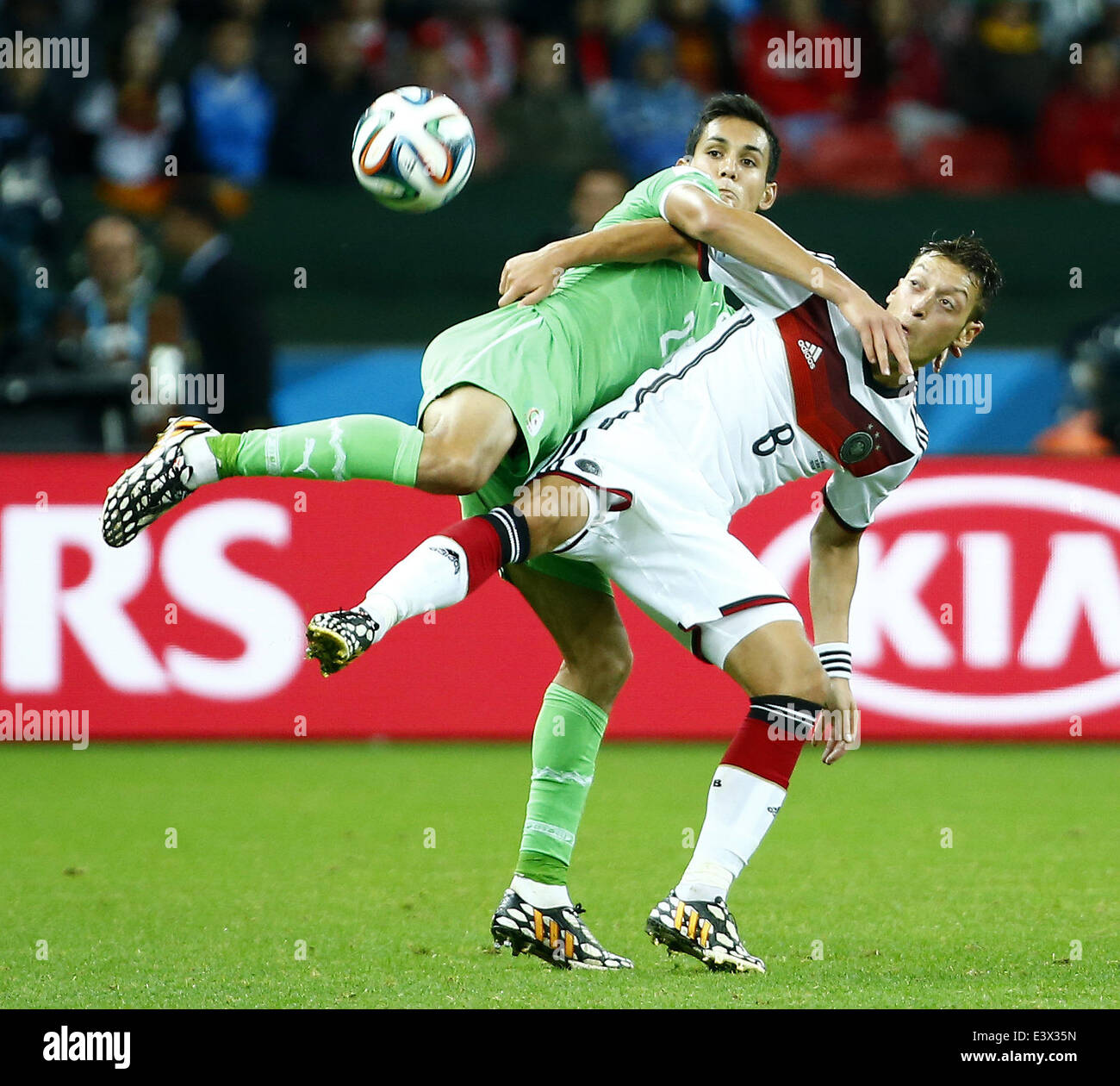 Porto Alegre, Brazil. 30th June, 2014. Germany's Mesut Ozil vies with Algeria's Aissa Mandi during a Round of 16 match between Germany and Algeria of 2014 FIFA World Cup at the Estadio Beira-Rio Stadium in Porto Alegre, Brazil, on June 30, 2014. Germany won 2-1 over Algeria after 120 minutes and qualified for quarter-finals on Monday. Credit:  Chen Jianli/Xinhua/Alamy Live News Stock Photo
