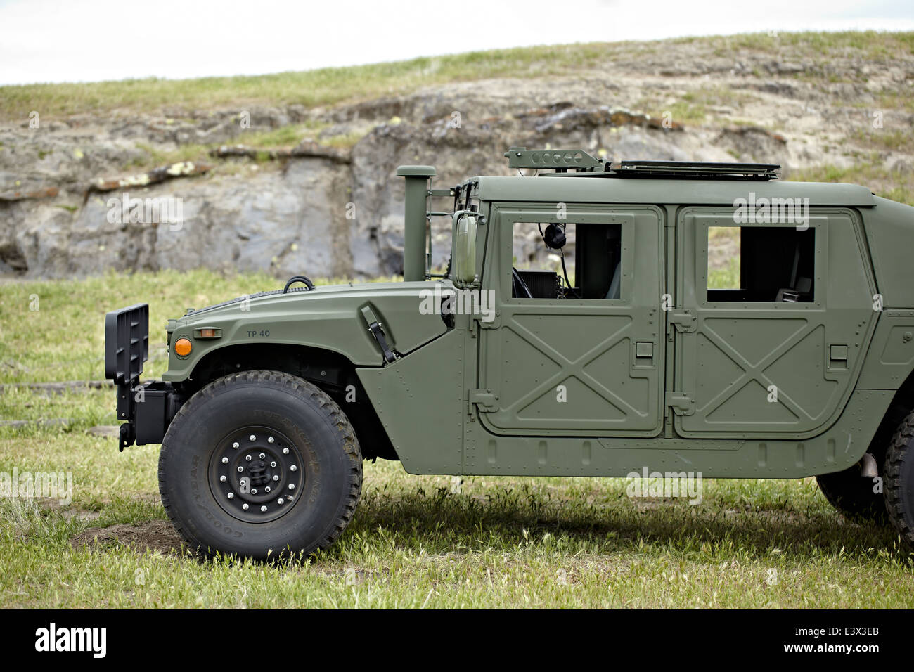Humvee parked in rocky area on field. Stock Photo
