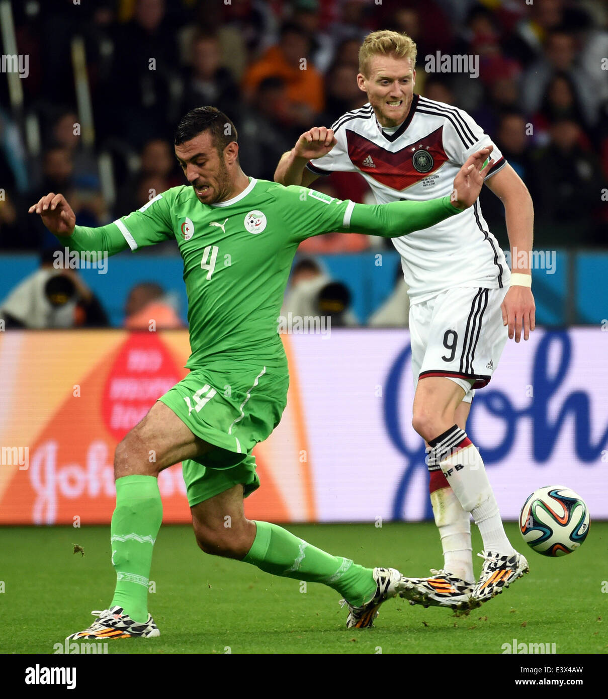 Porto Alegre, Brazil. 30th June, 2014. Algeria's Essaid Belkalem (L) vies with Germany's Andre Schurrle during a Round of 16 match between Germany and Algeria of 2014 FIFA World Cup at the Estadio Beira-Rio Stadium in Porto Alegre, Brazil, on June 30, 2014. Germany won 2-1 over Algeria after 120 minutes and qualified for quarter-finals on Monday. Credit:  Li Ga/Xinhua/Alamy Live News Stock Photo