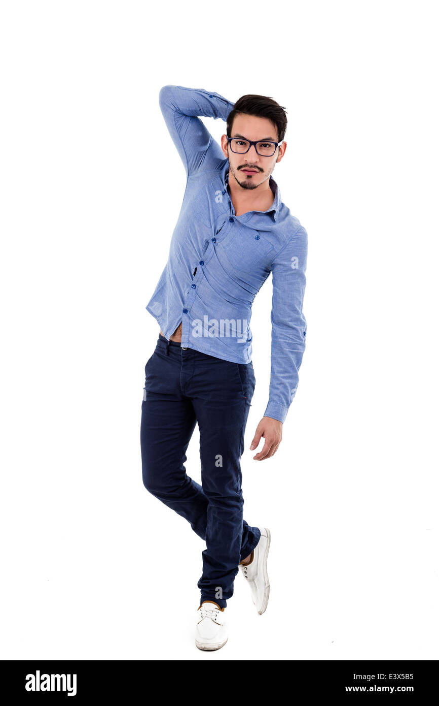 young hispanic man with blue shirt touching his hair posing Stock Photo ...