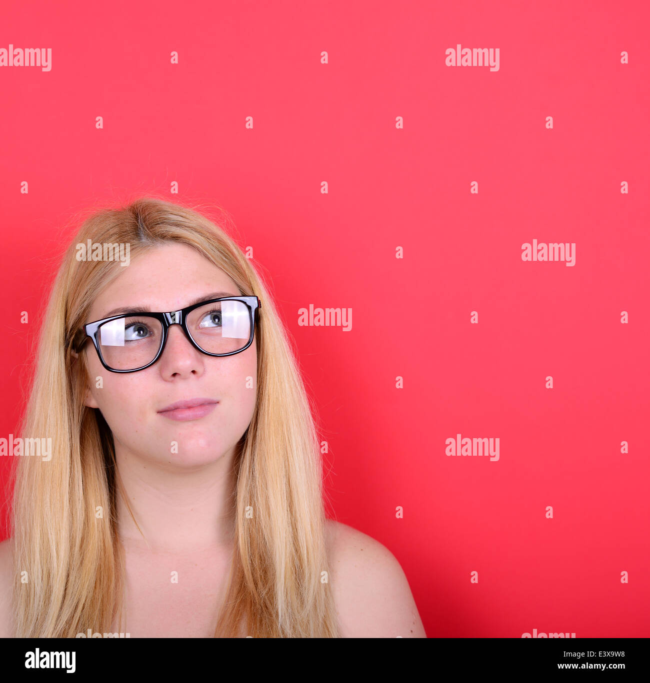 Portrait of beautiful girl looking up against red background Stock ...