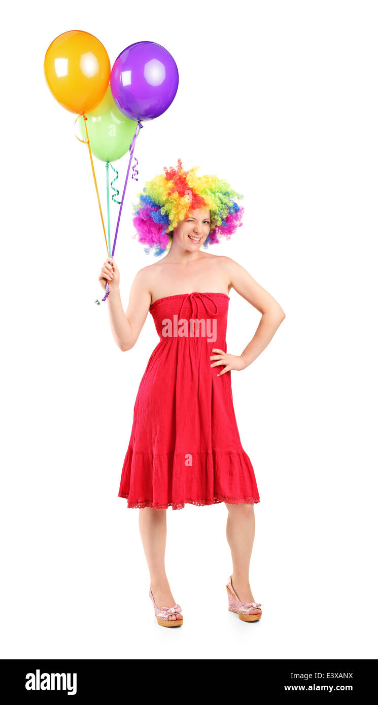 Full length portrait of a girl holding balloons and winks at the camera Stock Photo