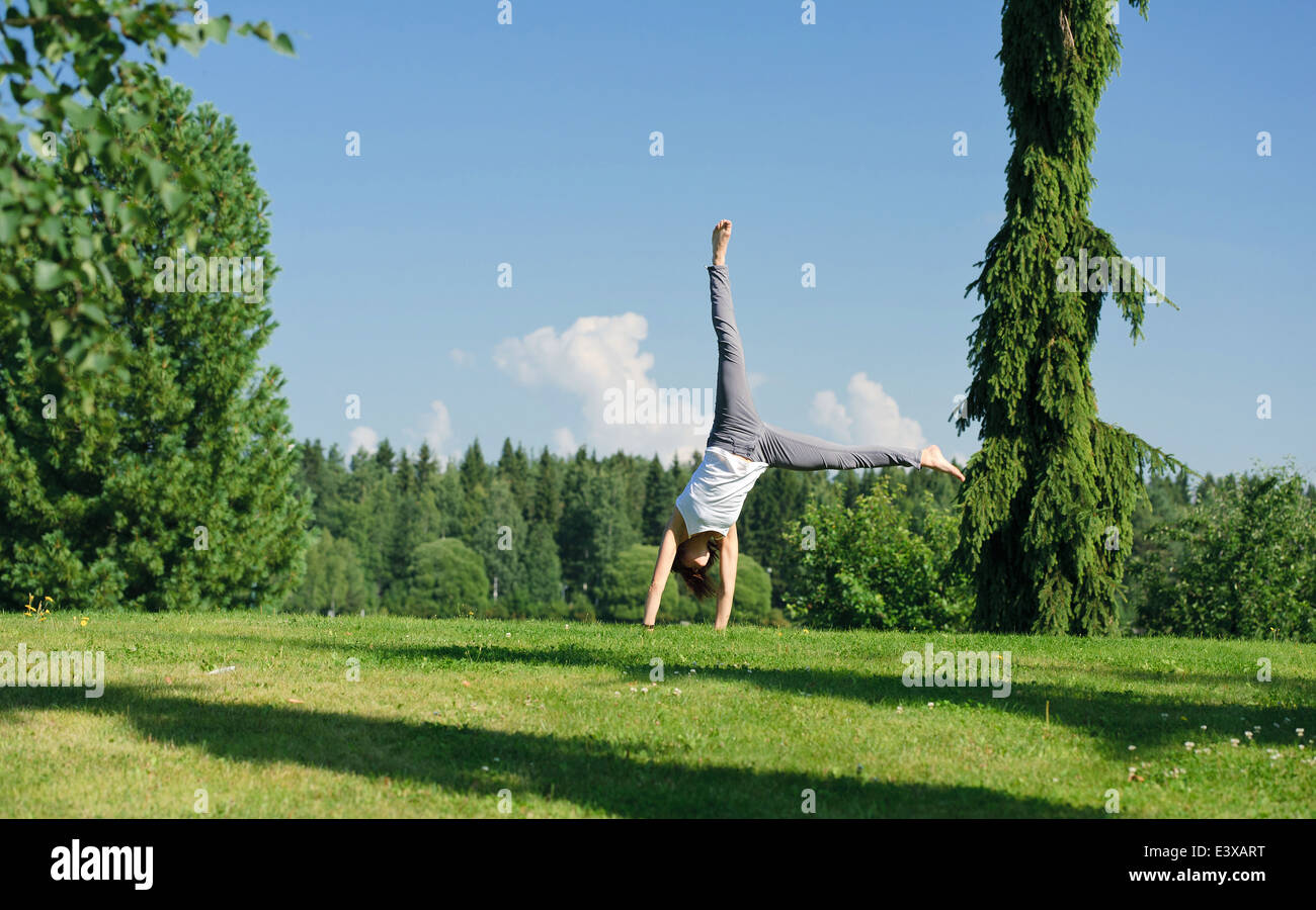 Young woman doing cartwheel outside Stock Photo