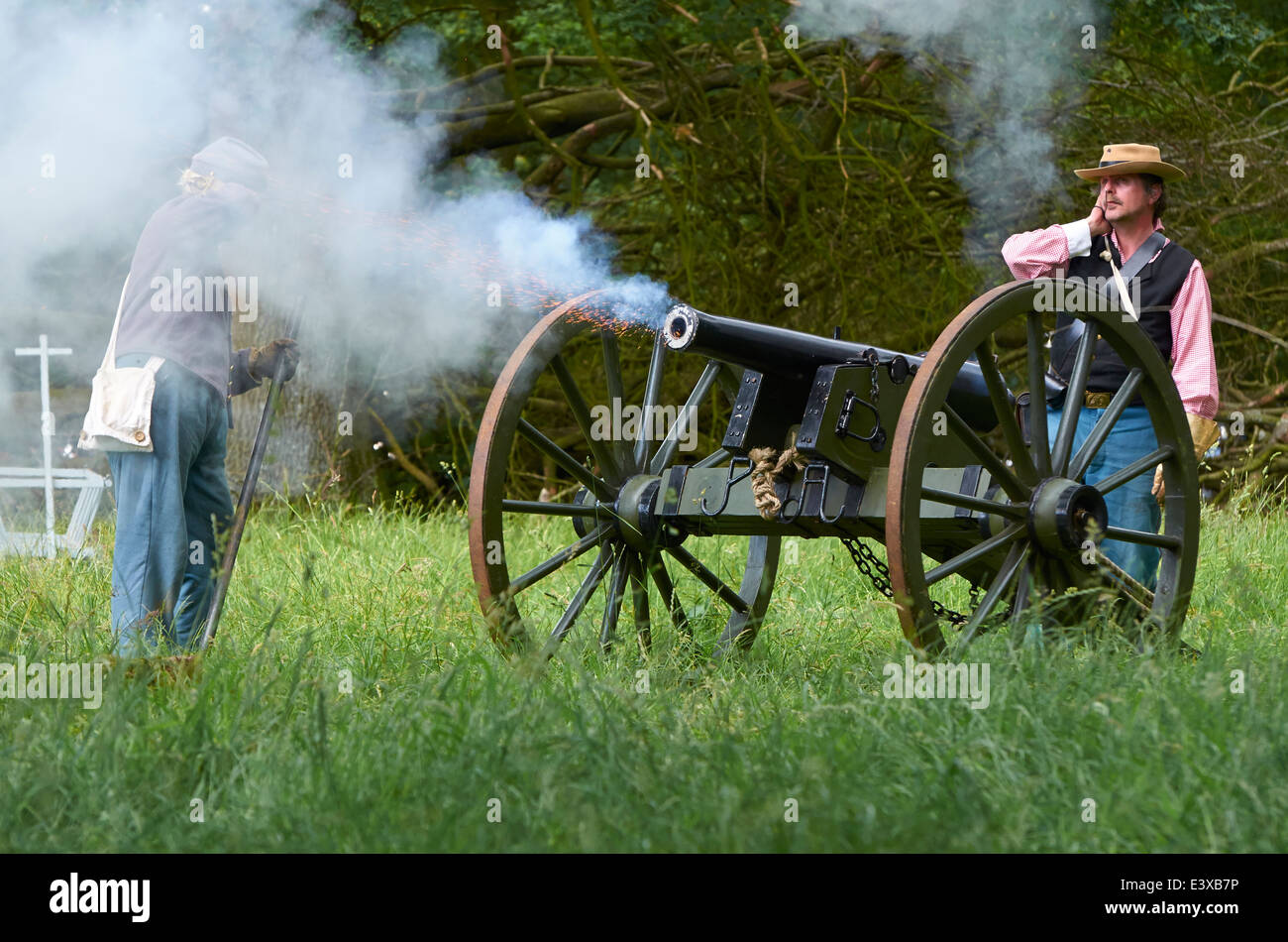 Actors in Confederate uniform firing a cannon as part of an American Civil War battle re-enactment. Stock Photo
