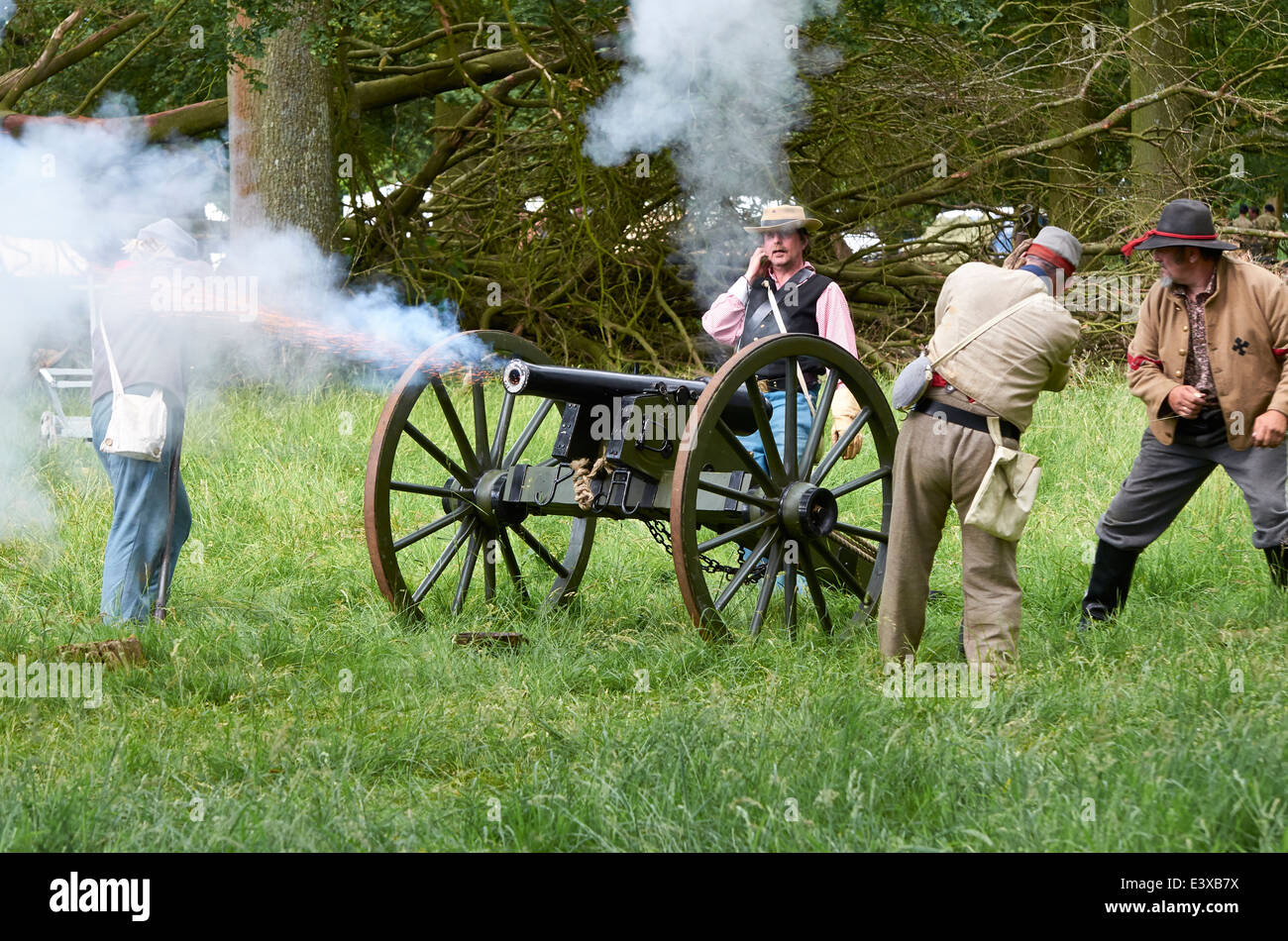 Actors in Confederate uniform firing a cannon as part of an American Civil War battle re-enactment. Stock Photo