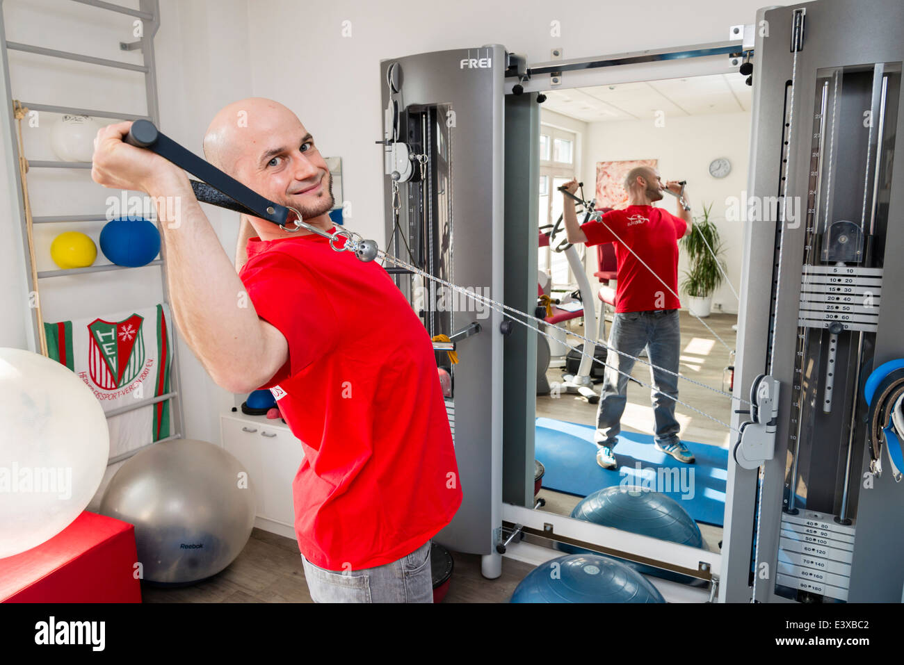 A physiotherapist shows an exercise that strengthens backbone and back muscles. Stock Photo