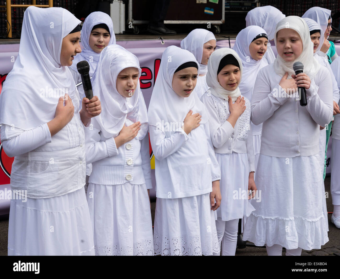 Young girls of Turkish origin who live in Germany sing religious songs, wearing traditional Turkish clothes. Stock Photo