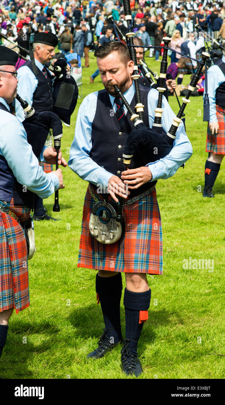 A BAGPIPE PLAYER TESTS HIS INSTRUMENT AT THE EUROPEAN PIPE BAND CHAMPIONSHIPS IN FORRES SCOTLAND 2014 Stock Photo