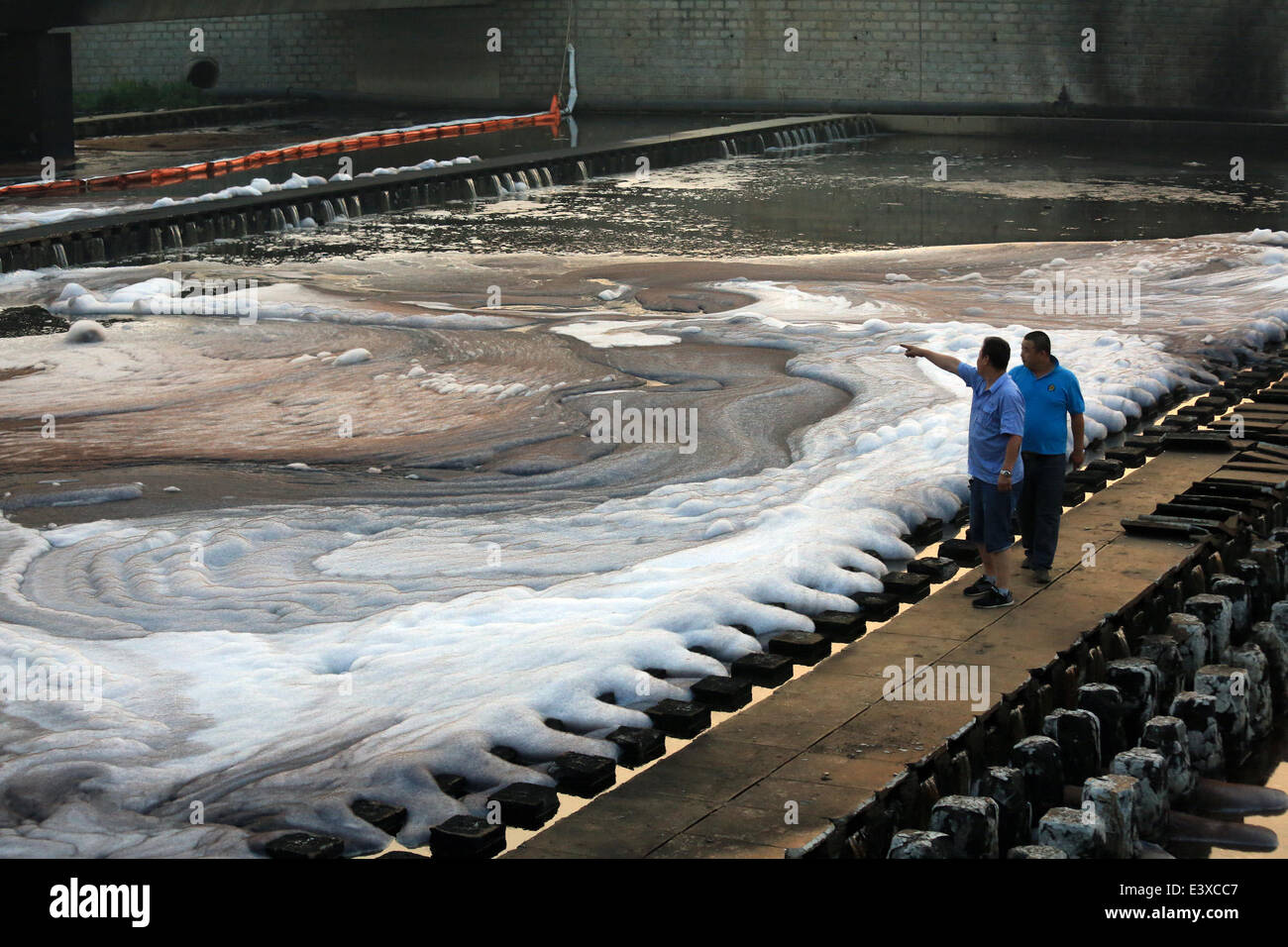 Dalian, China. 1st July, 2014. Working staff check the crude oil spills