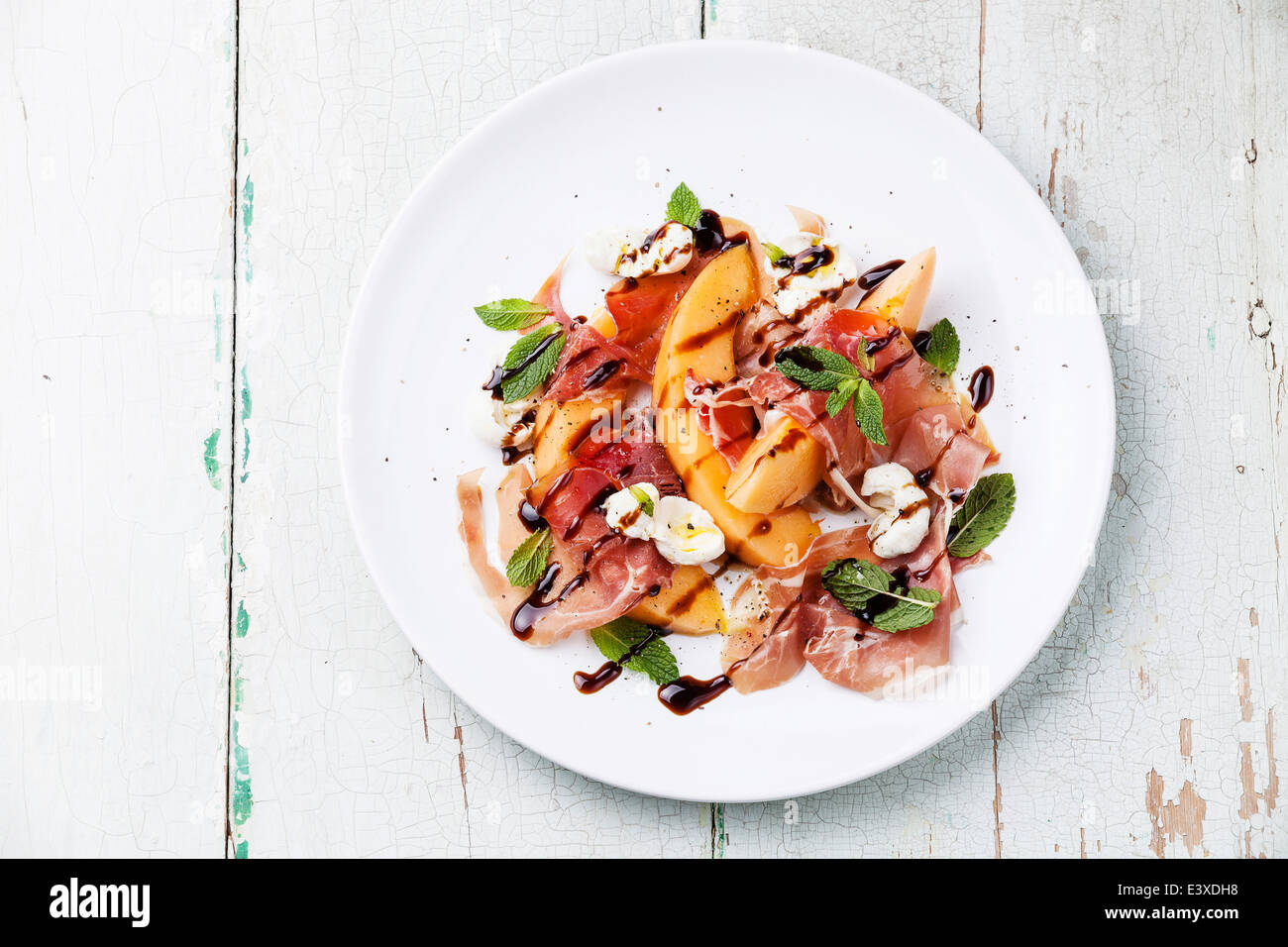 Melon and prosciutto ham salad with Mozzarella and mint leaves Stock Photo