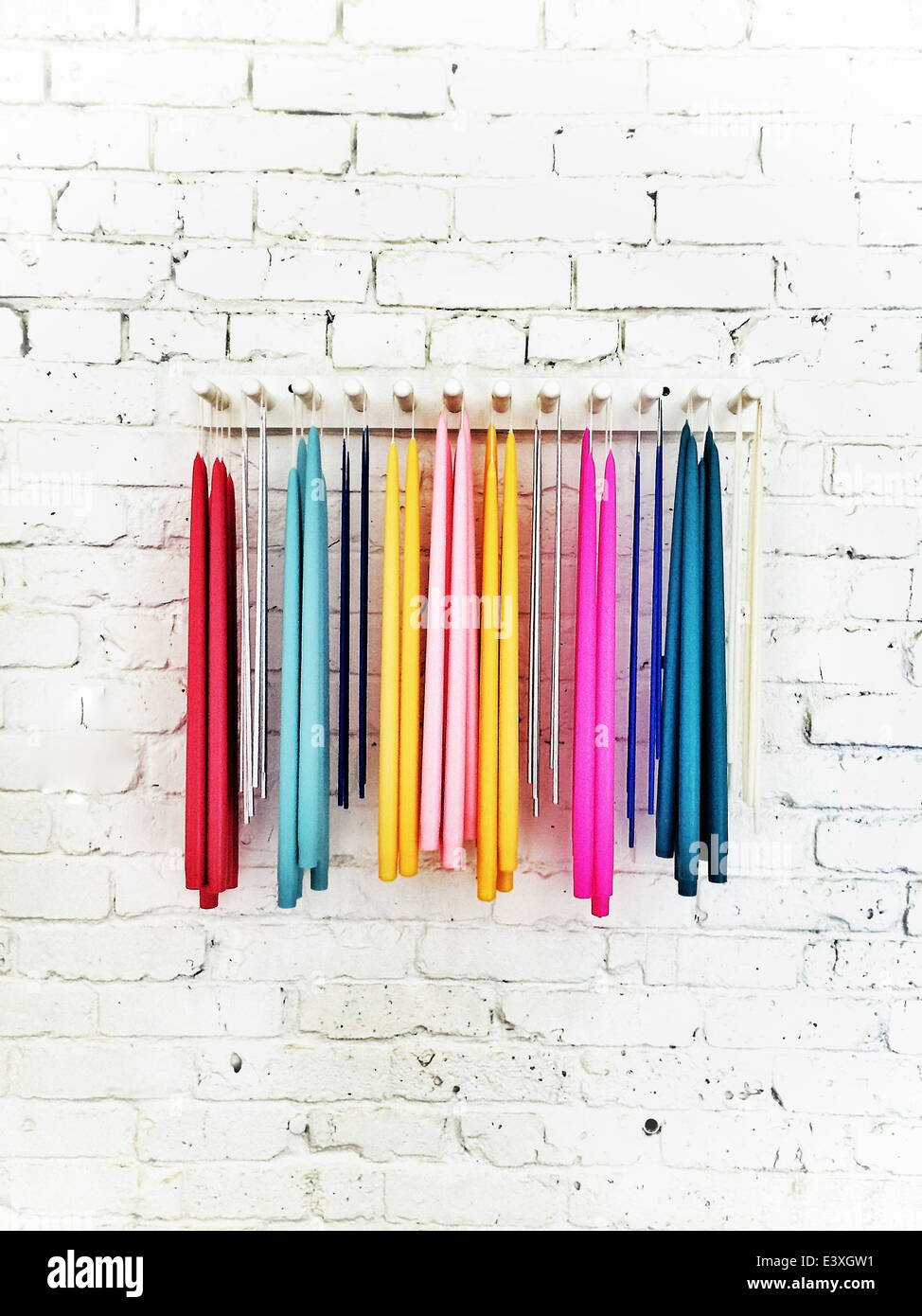 Colorful fabrics hanging from rack on wall Stock Photo Alamy