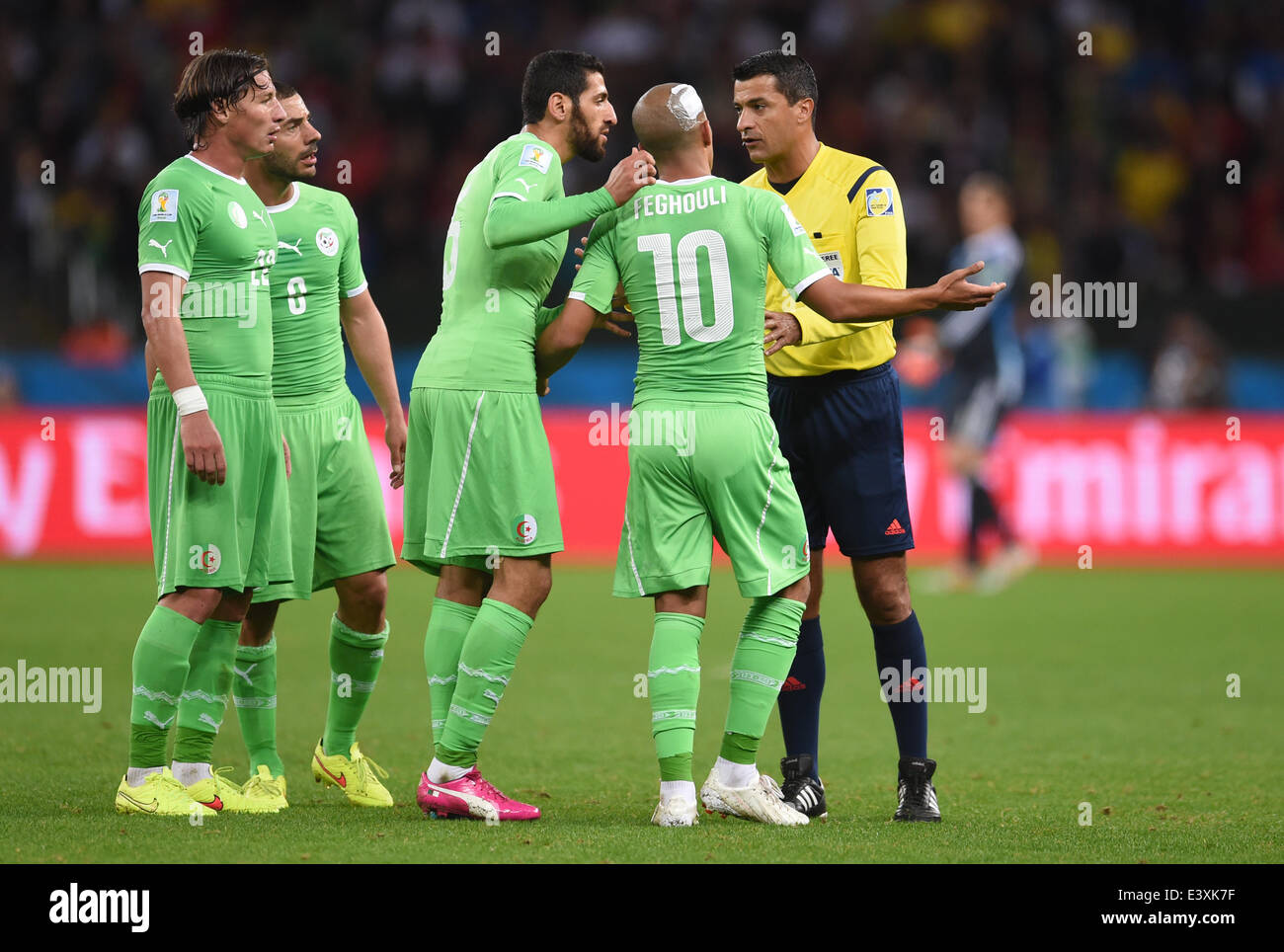 Algerian players (from L) Mehdi Mostefa, Djamel Mesbah, Rafik Halliche and Sofiane Feghouli talk wiht Brazilian referee Sandro Ricci  during the FIFA World Cup 2014 round of 16 match between Germany and Algeria at the Estadio Beira-Rio in Porto Alegre, Brazil, 30 June 2014.Photo: Andreas Gebert/dpa (RESTRICTIONS APPLY: Editorial Use Only, not used in association with any commercial entity - Images must not be used in any form of alert service or push service of any kind including via mobile alert services, downloads to mobile devices or MMS messaging - Images must appear as still images and mu Stock Photo