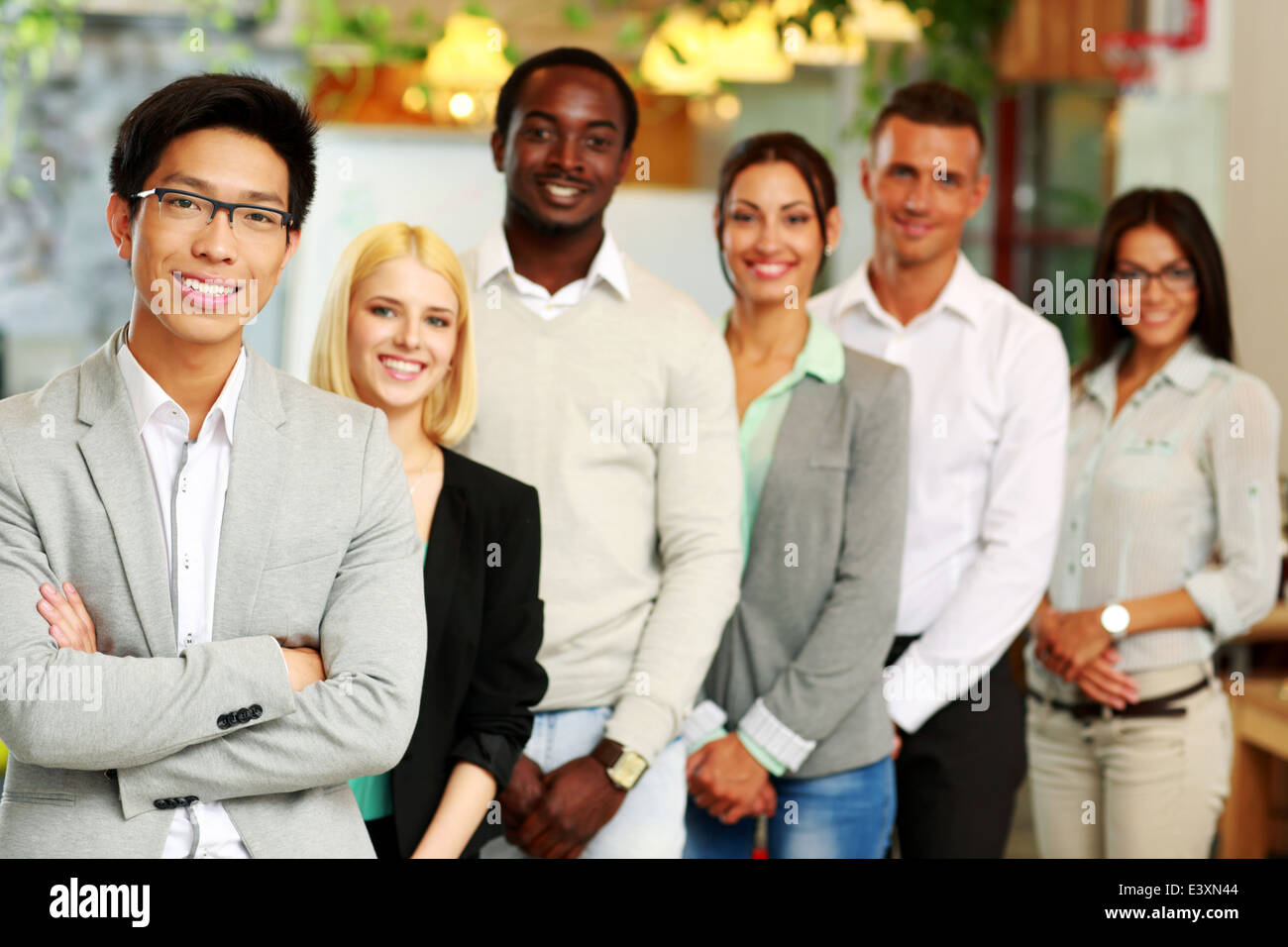 Portrait of a smiling asian businessman standing in front of colleagues Stock Photo