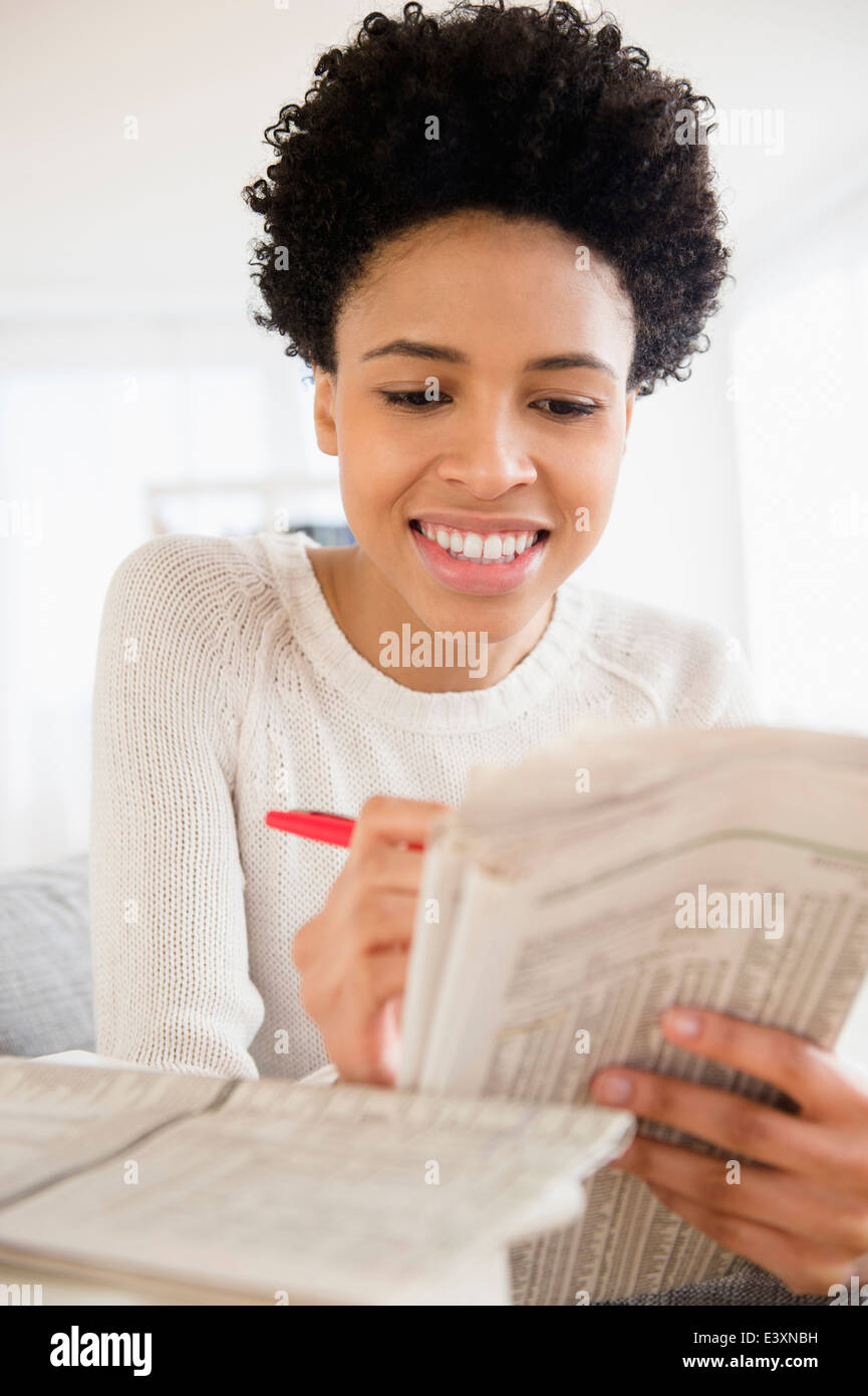 Black woman searching for jobs in newspaper Stock Photo