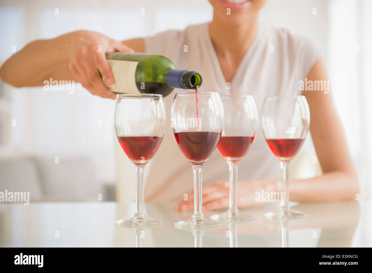 Black woman pouring glasses of wine Stock Photo