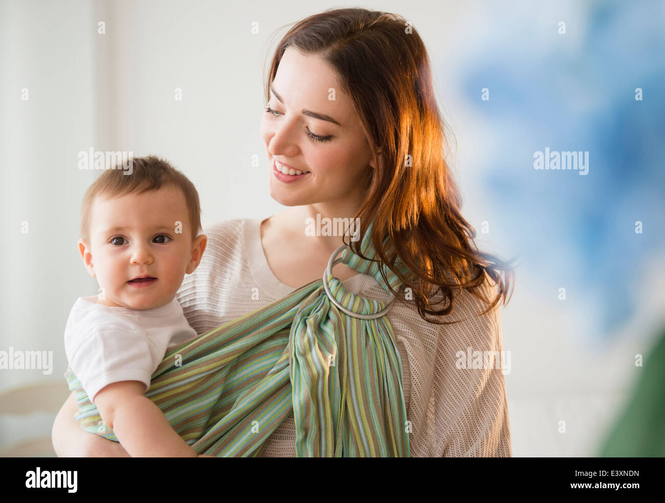 Mother carrying baby in sling Stock Photo