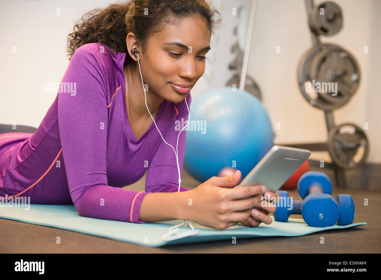 Mixed race woman using digital tablet to exercise Stock Photo