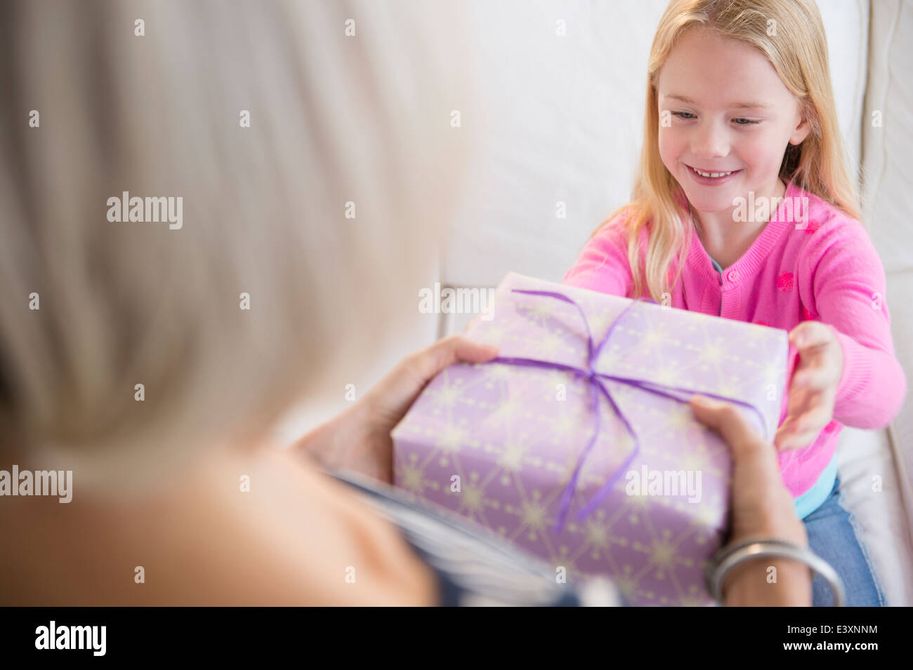 Senior Caucasian woman giving granddaughter present Stock Photo