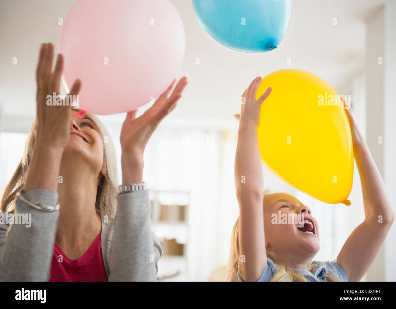 Senior Caucasian woman and granddaughter playing with balloons Stock Photo