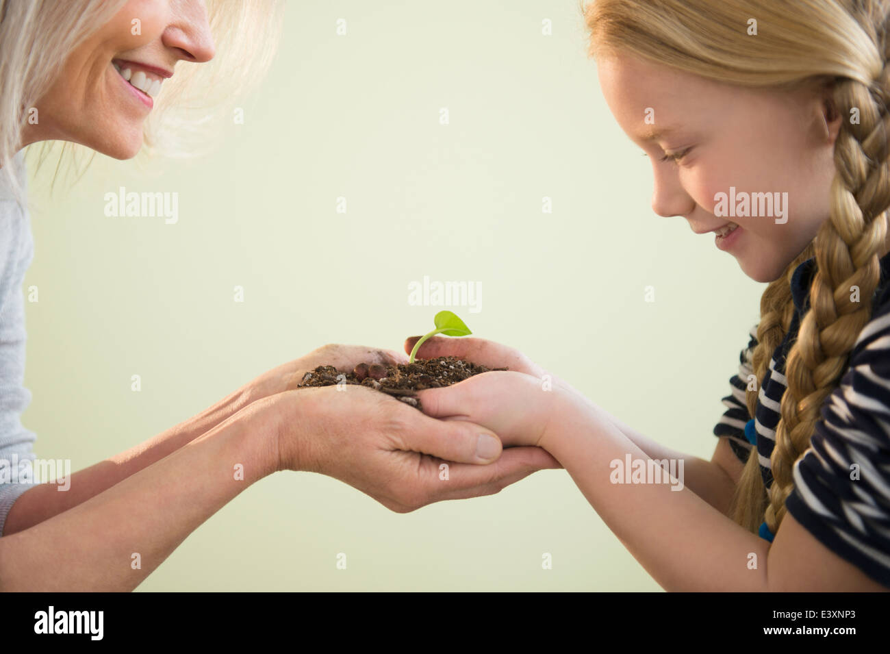 Senior Caucasian woman and granddaughter admiring plant shoot Stock Photo