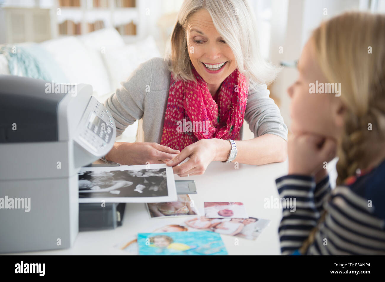 Senior Caucasian woman and granddaughter printing photos Stock Photo