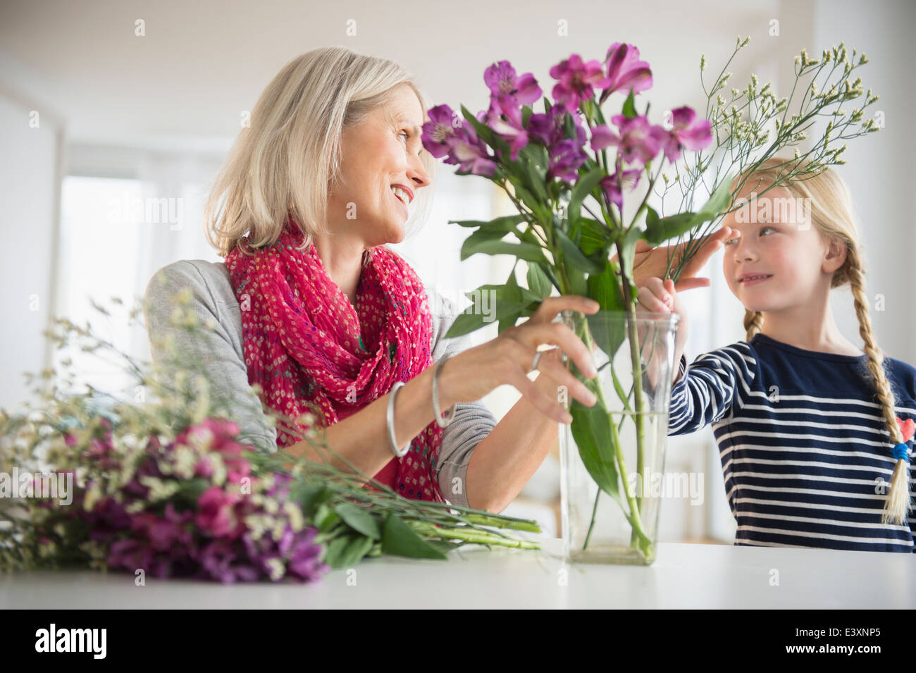 Senior Caucasian woman and granddaughter arranging flowers Stock Photo