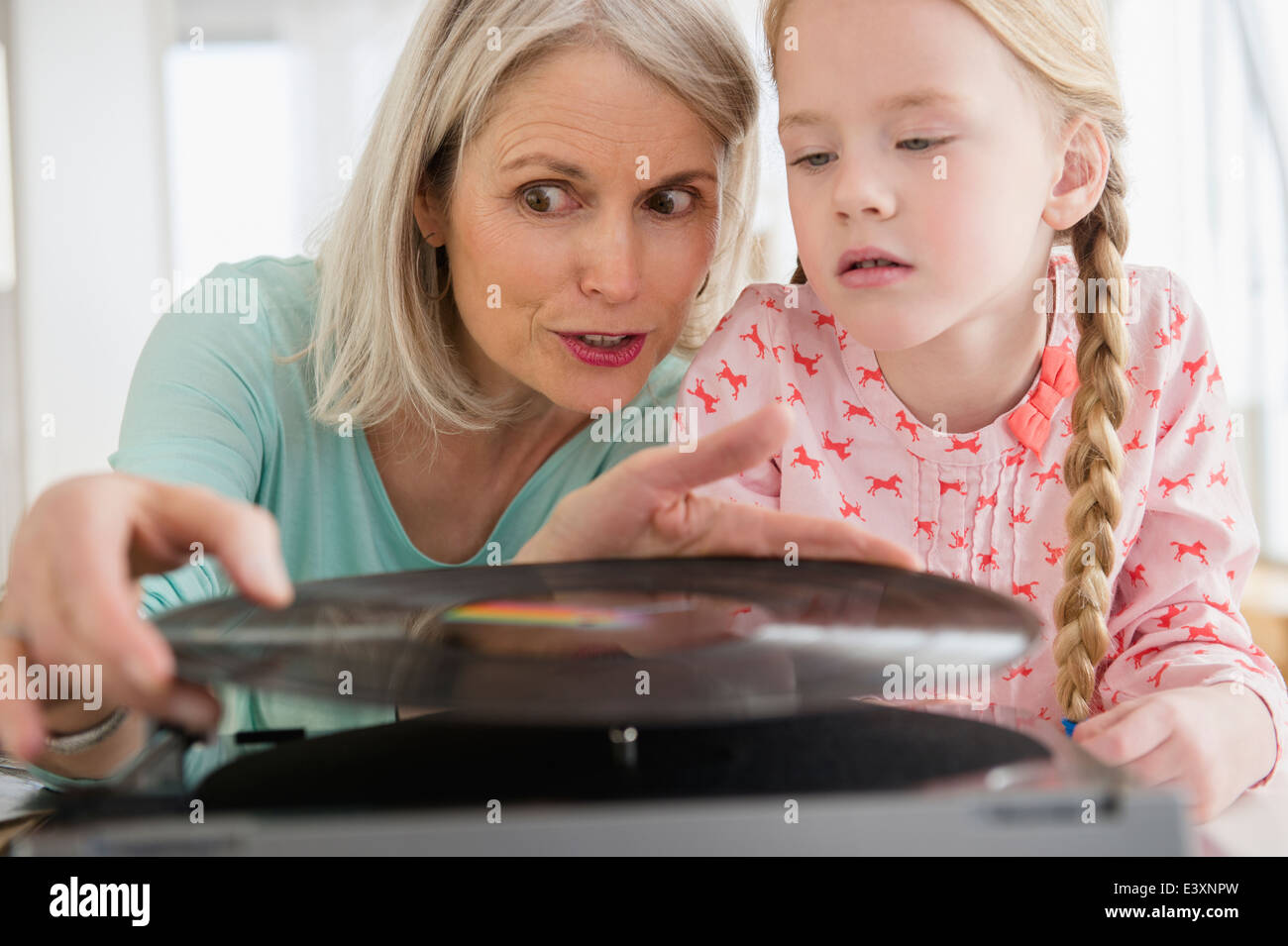 Senior Caucasian woman and granddaughter listening to records Stock Photo