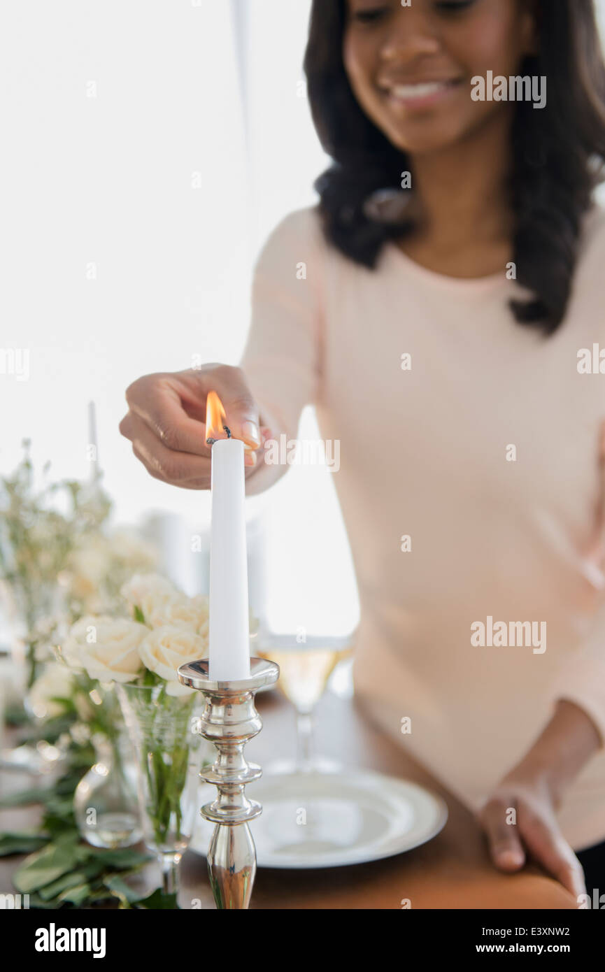 African American woman lighting candle Stock Photo Alamy
