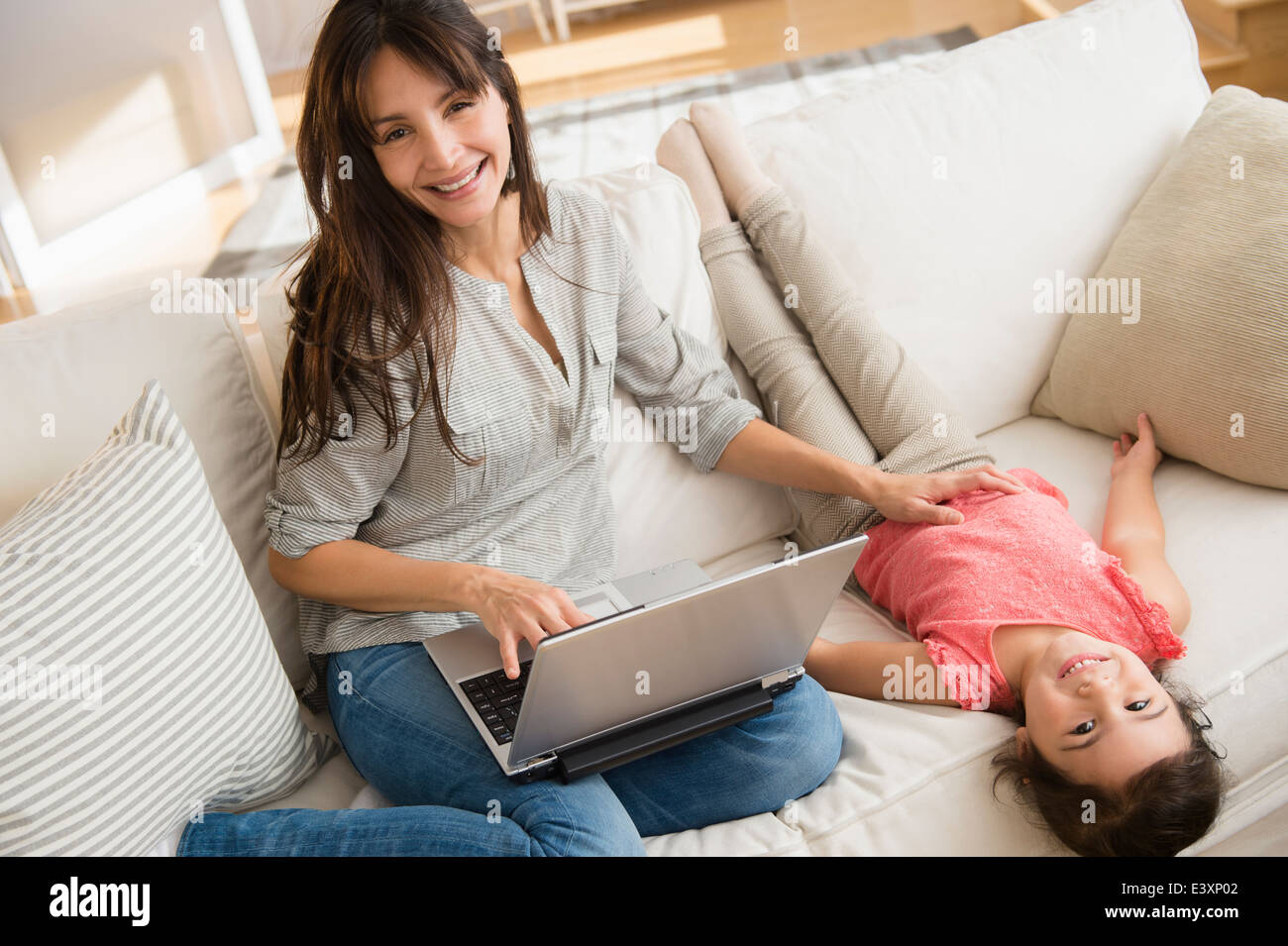 Hispanic mother and daughter relaxing on sofa Stock Photo