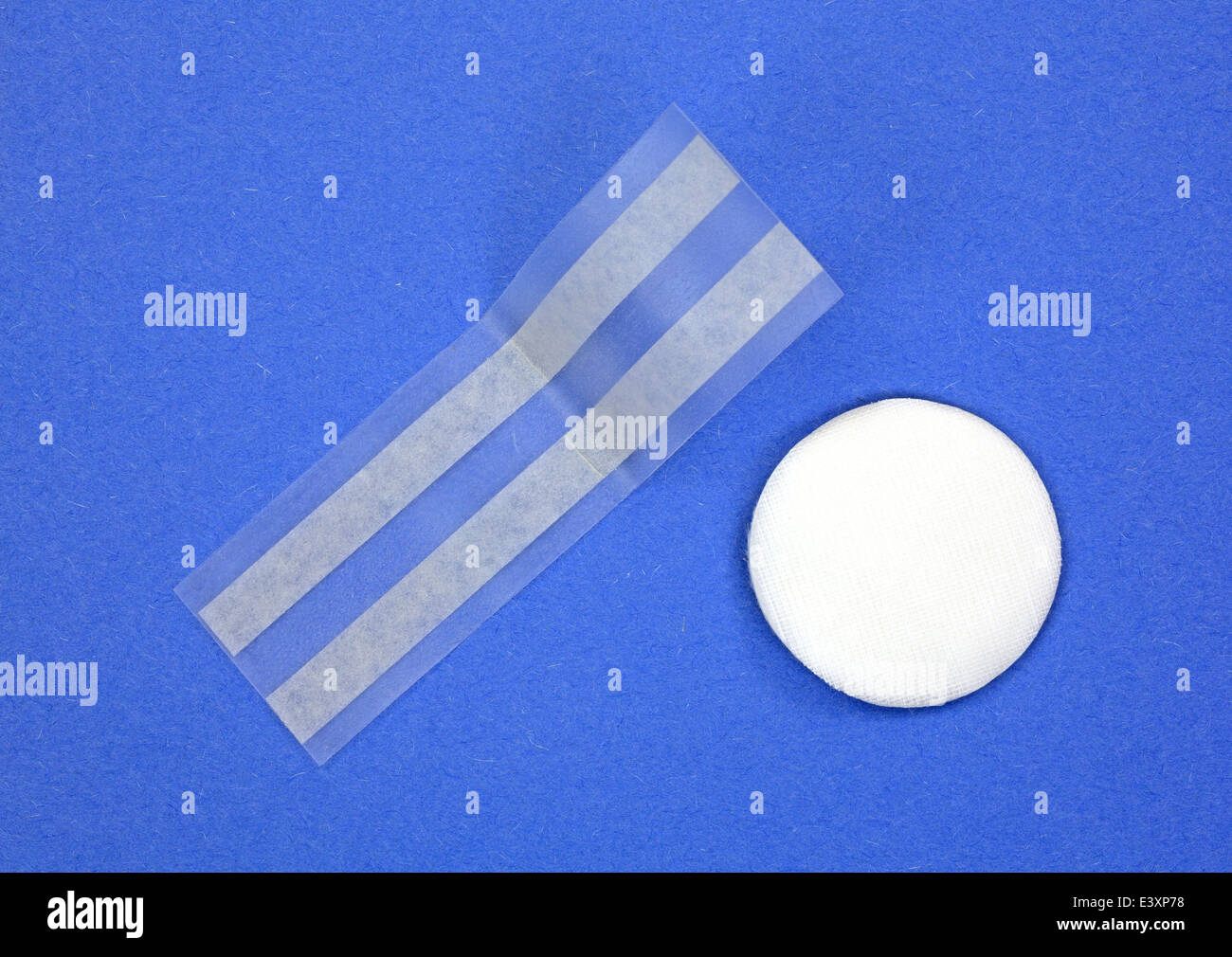 A single first aid eye patch with two adhesive strips on a yellow background. Stock Photo