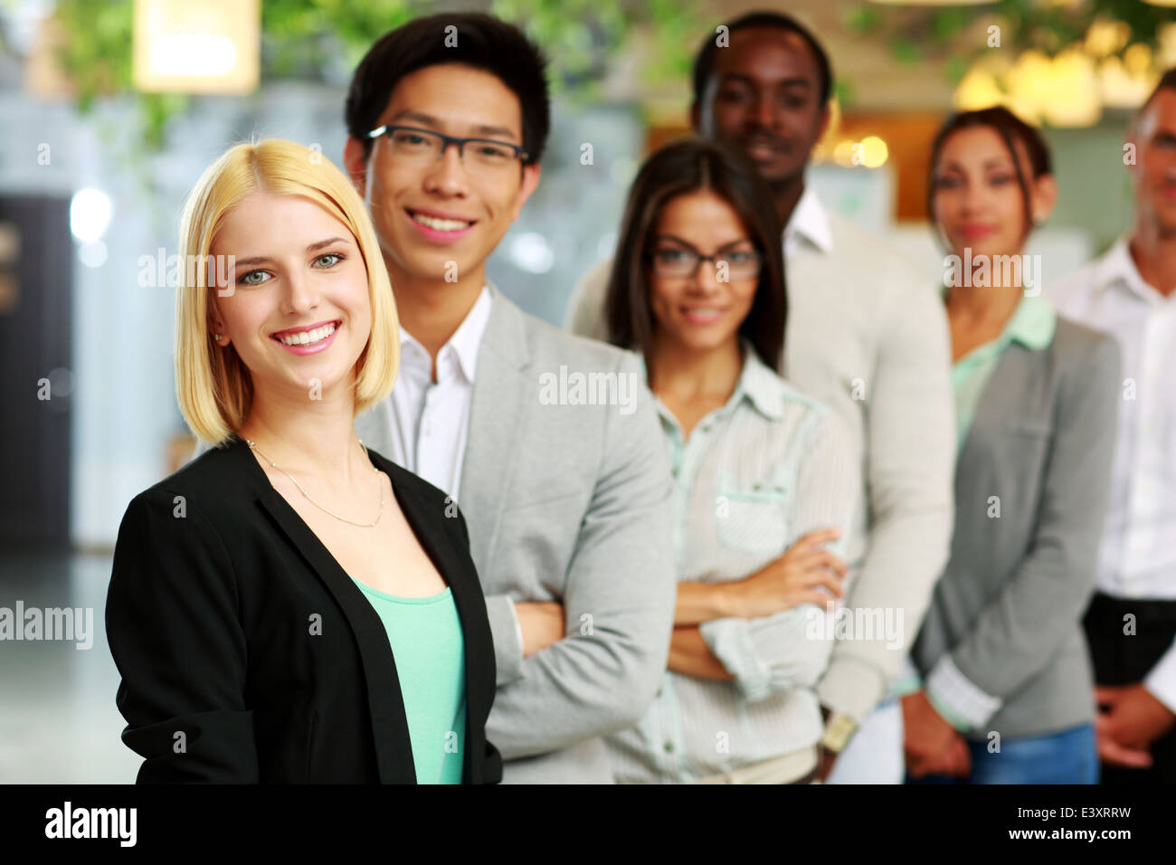 Portrait of a smiling businesswoman standing in front of colleagues Stock Photo