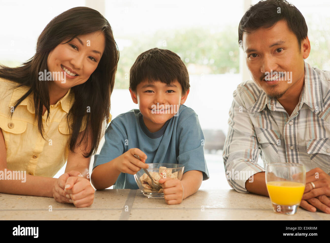 Family smiling together at breakfast table Stock Photo - Alamy