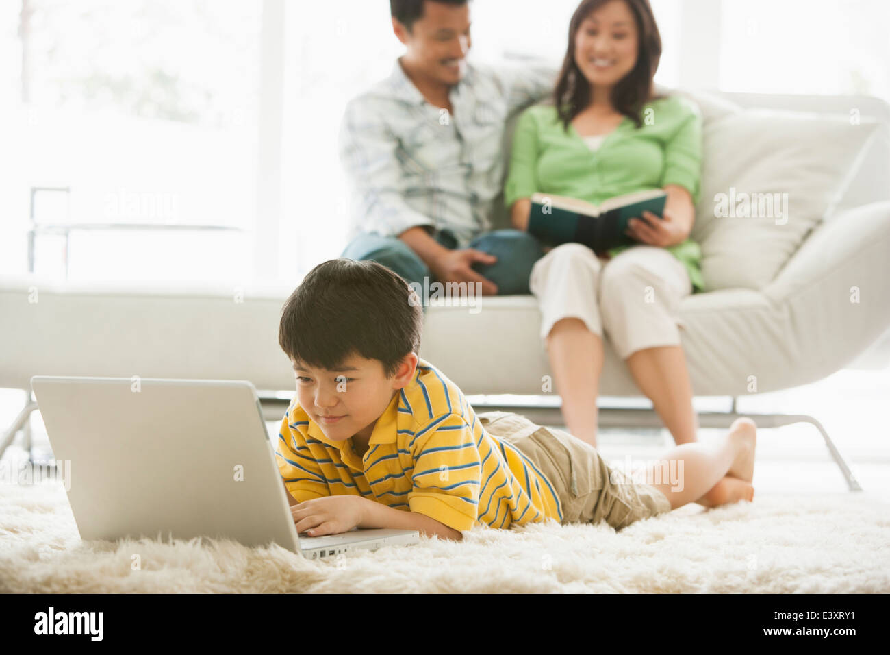 Boy using laptop in living room Stock Photo - Alamy
