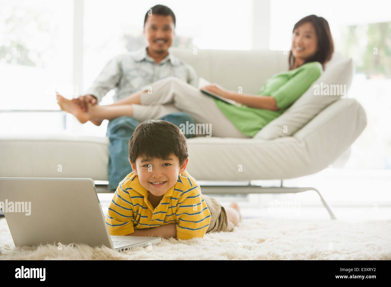 Boy using laptop in living room Stock Photo - Alamy