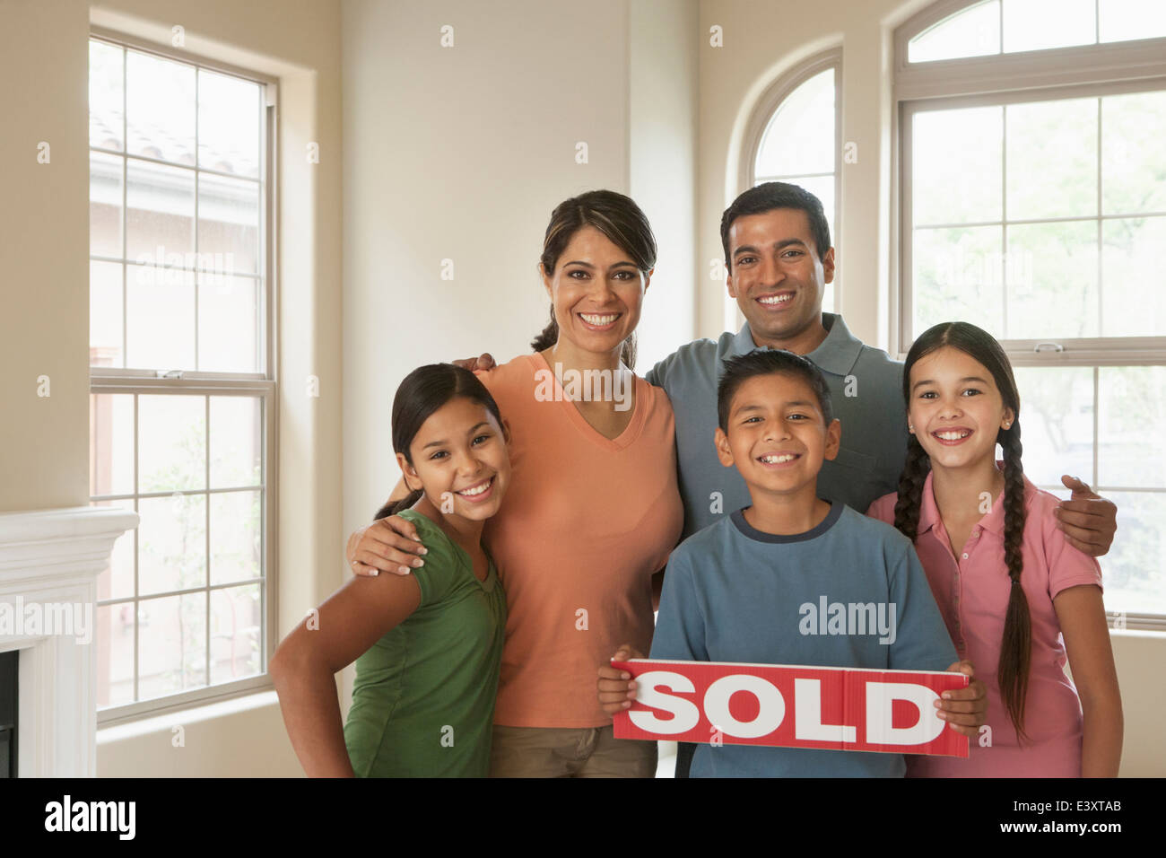 Hispanic family smiling in new home Stock Photo - Alamy