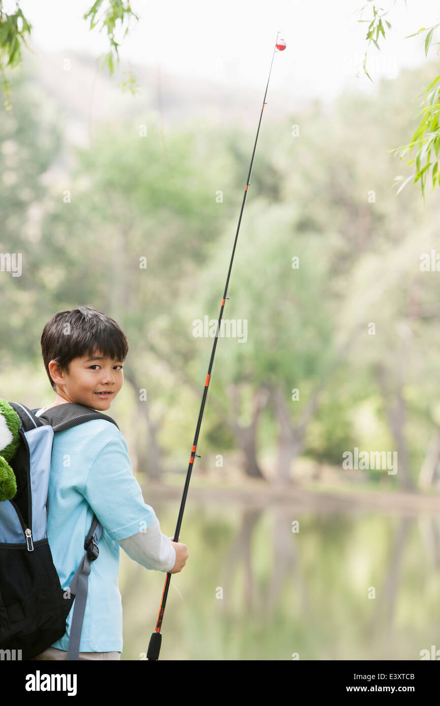 Boy carrying fishing rod on hi-res stock photography and images
