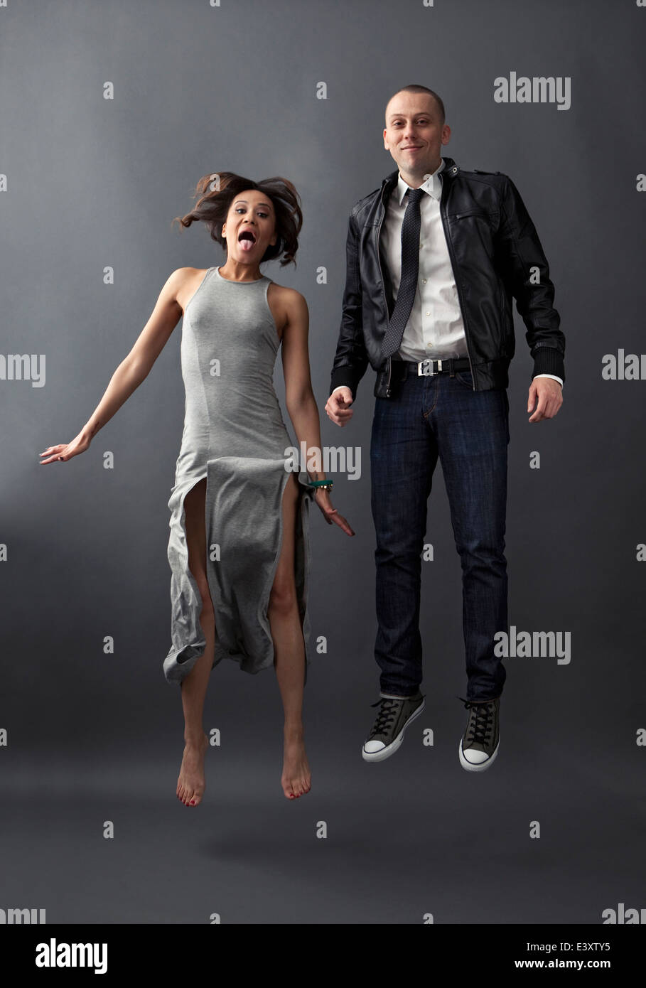 Couple jumping together in studio Stock Photo