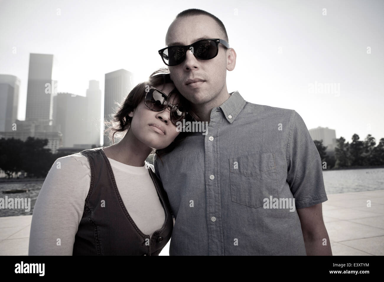 Couple wearing sunglasses on urban waterfront Stock Photo