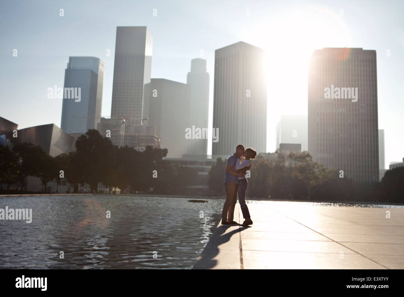 Couple kissing by urban waterfront Stock Photo