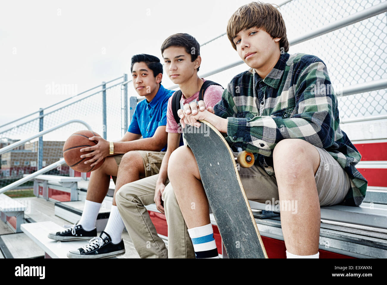 Teenage boys sitting on bleachers Stock Photo