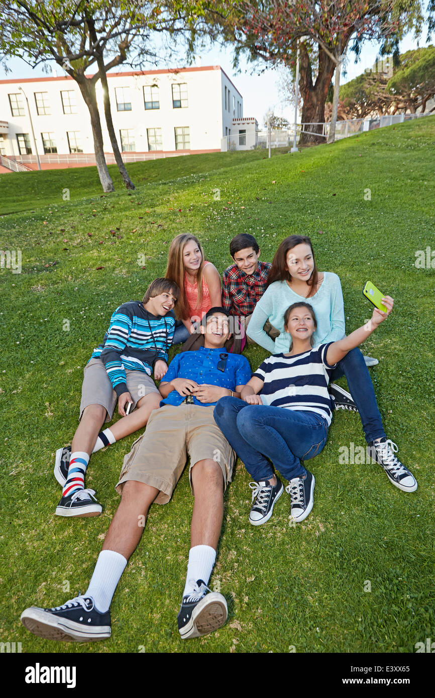 Teenagers taking picture together in grass Stock Photo