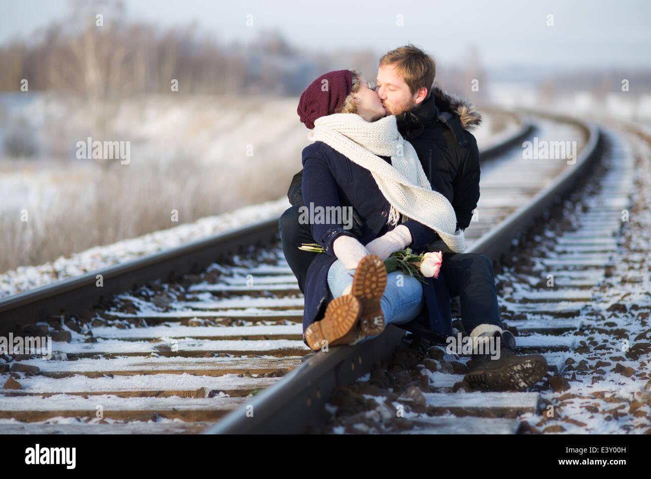 Young couple kissing on railway Stock Photo