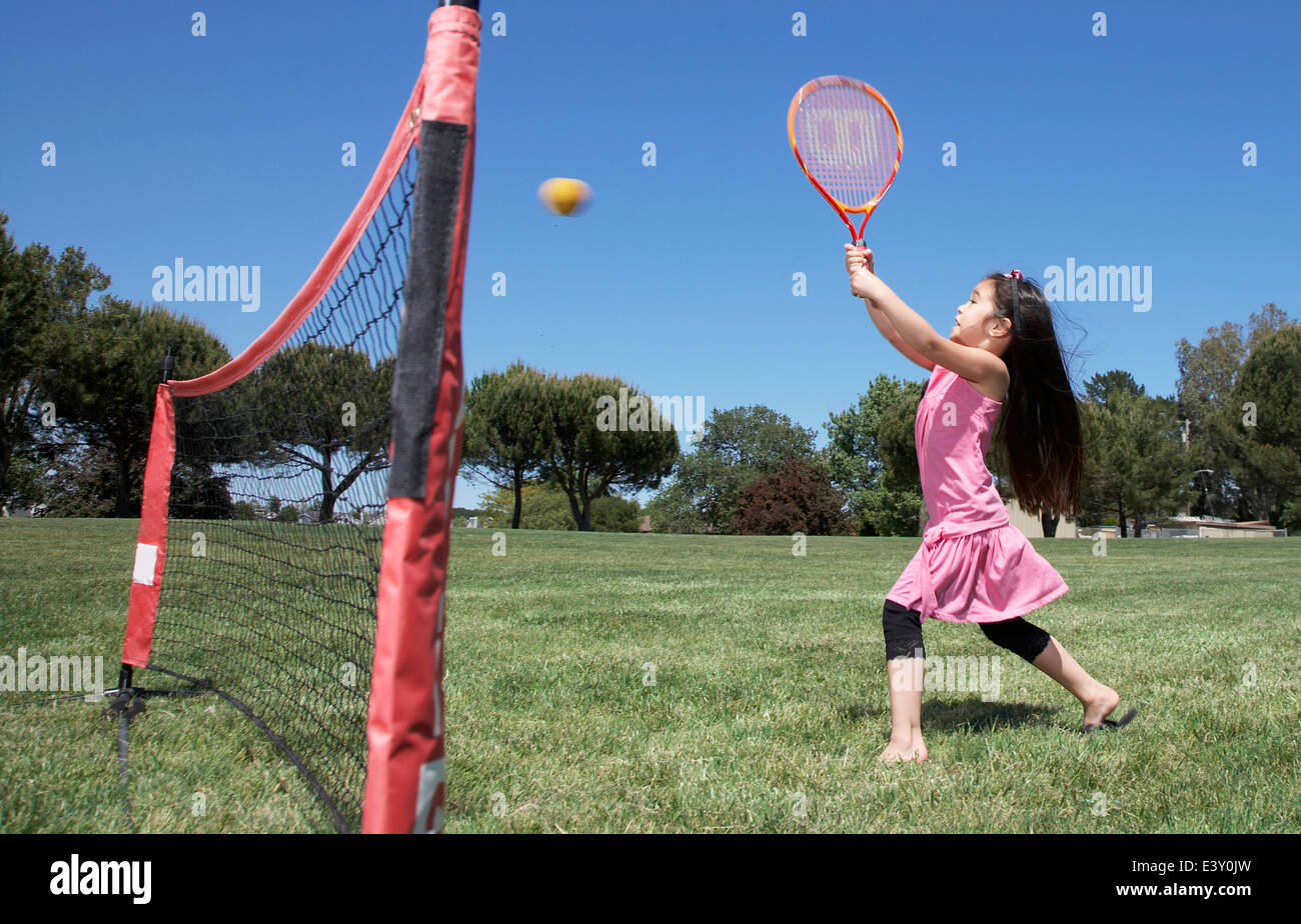 Girl  playing tennis in park Stock Photo