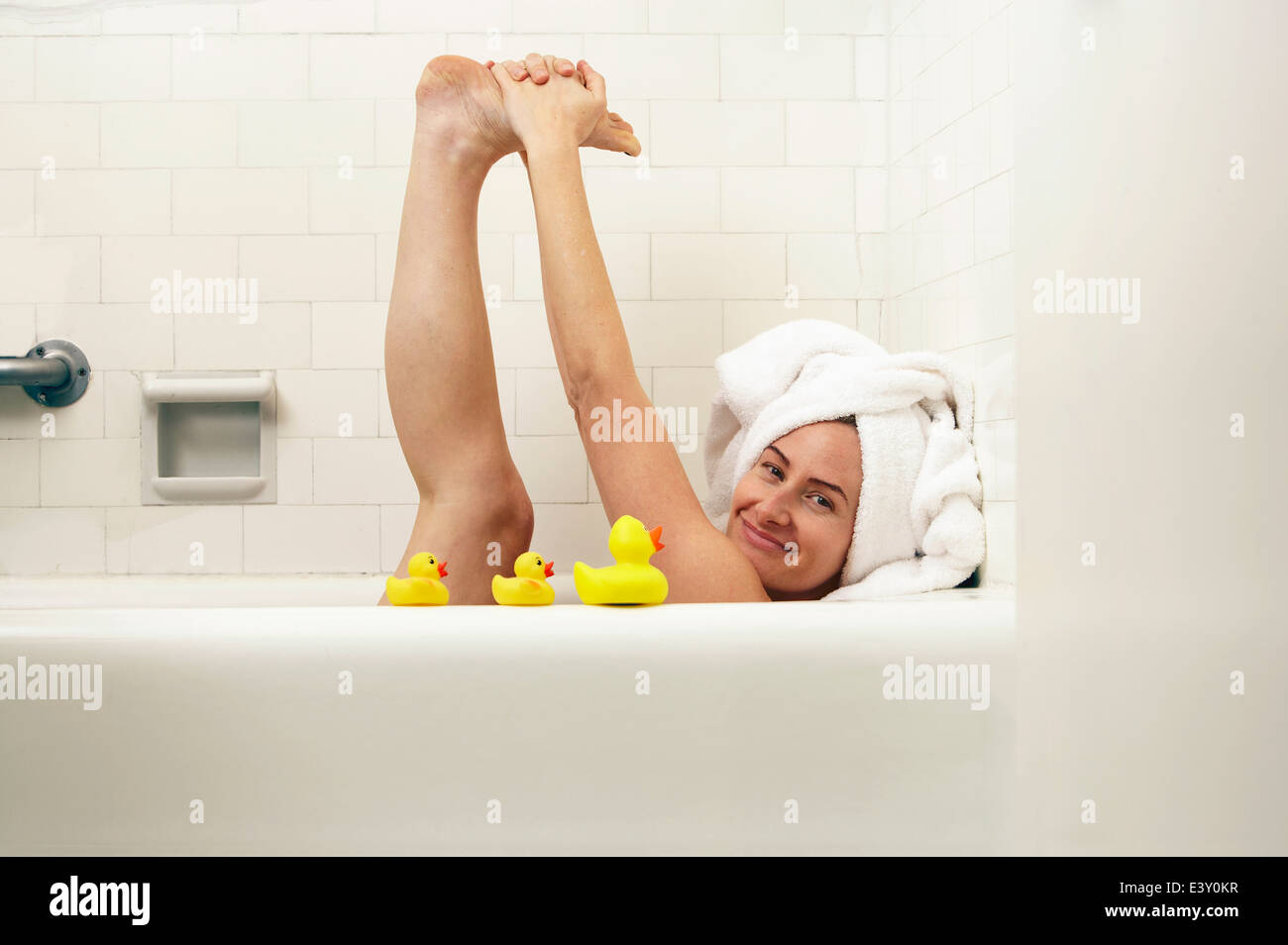 Caucasian woman playing in bath Stock Photo